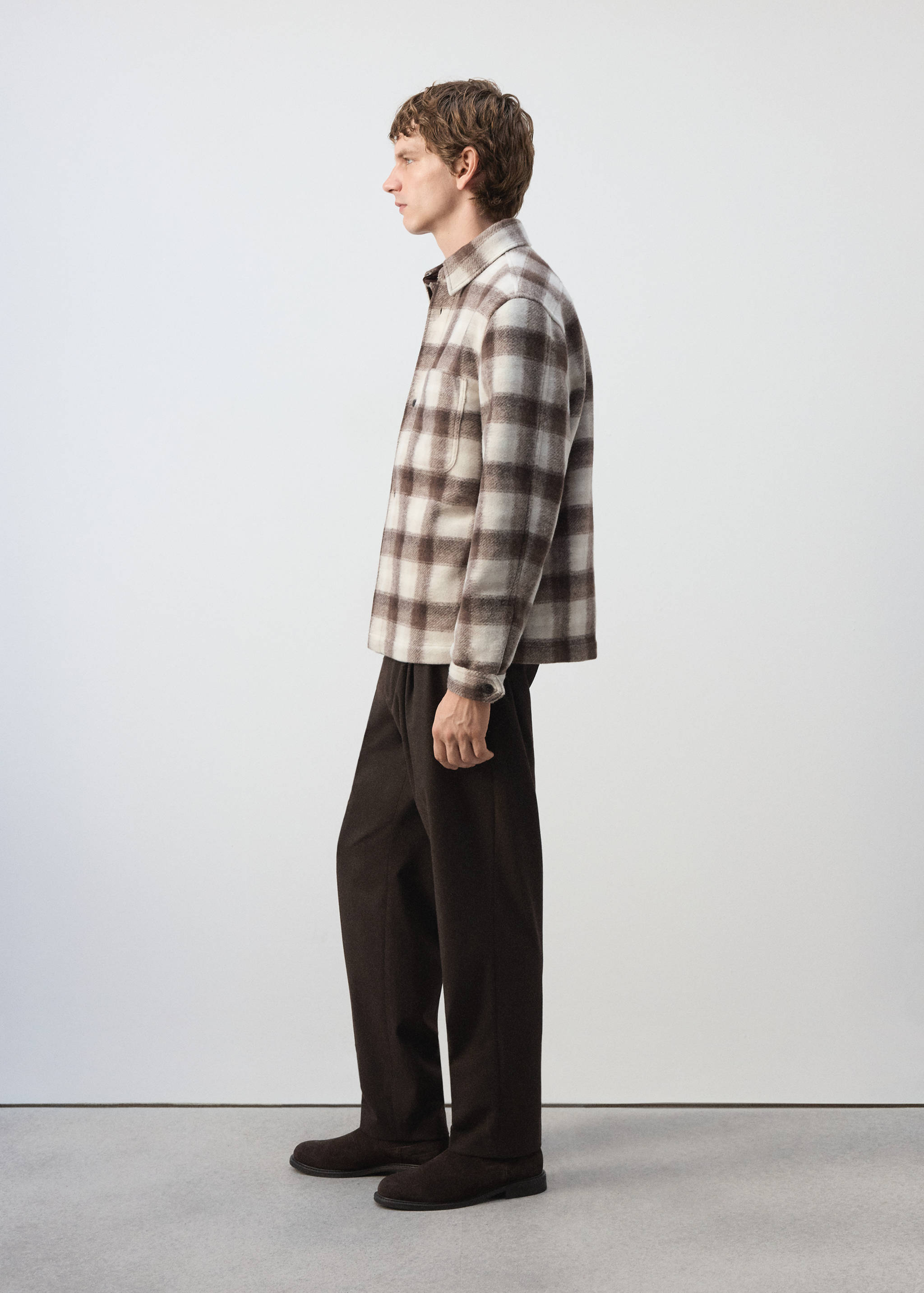 Sobrecamisa de cuadros en marrón y blanco con cuello en punta y bolsillo en el pecho.