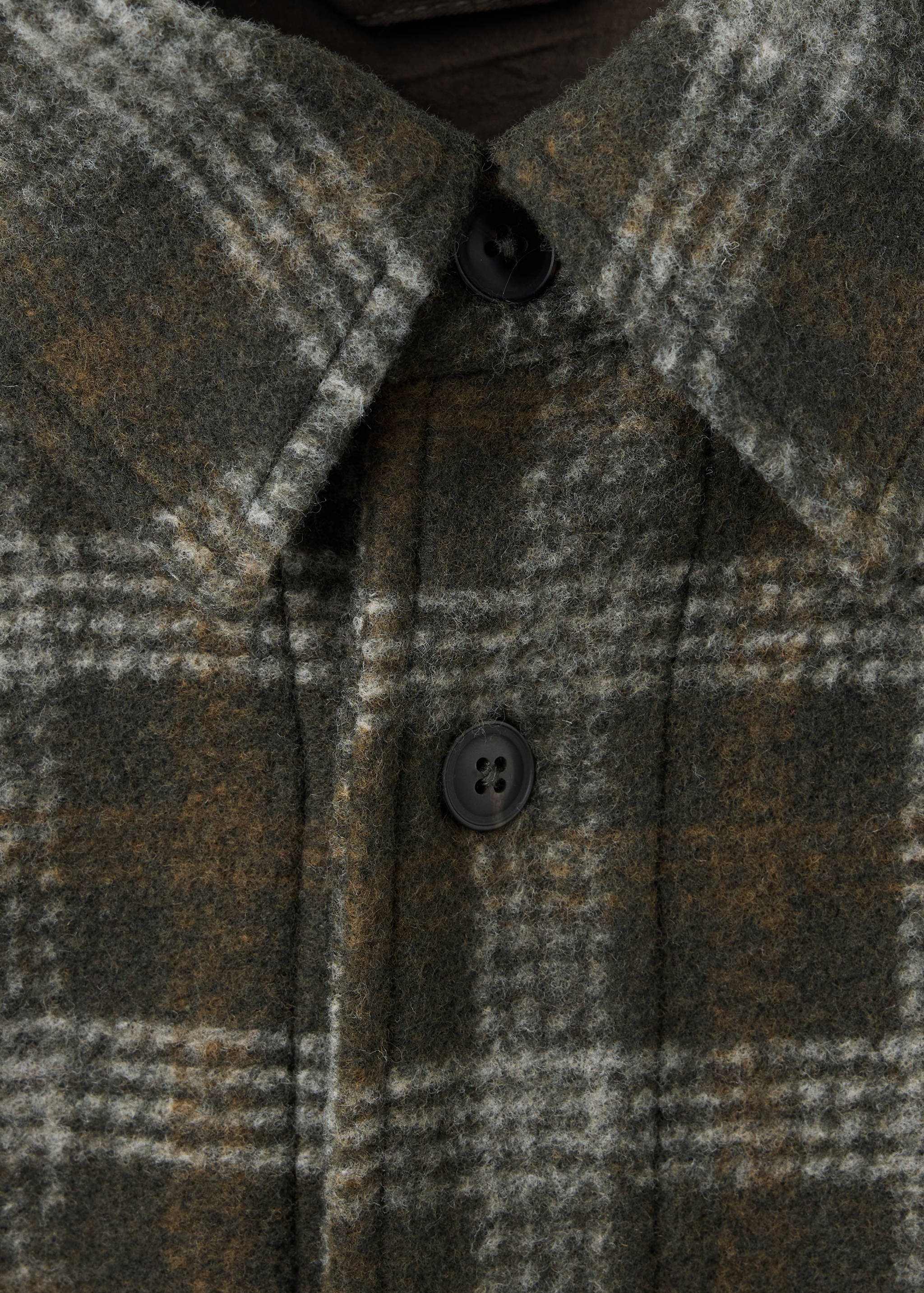 Detalle de sobrecamisa de cuadros en verde oliva y gris.