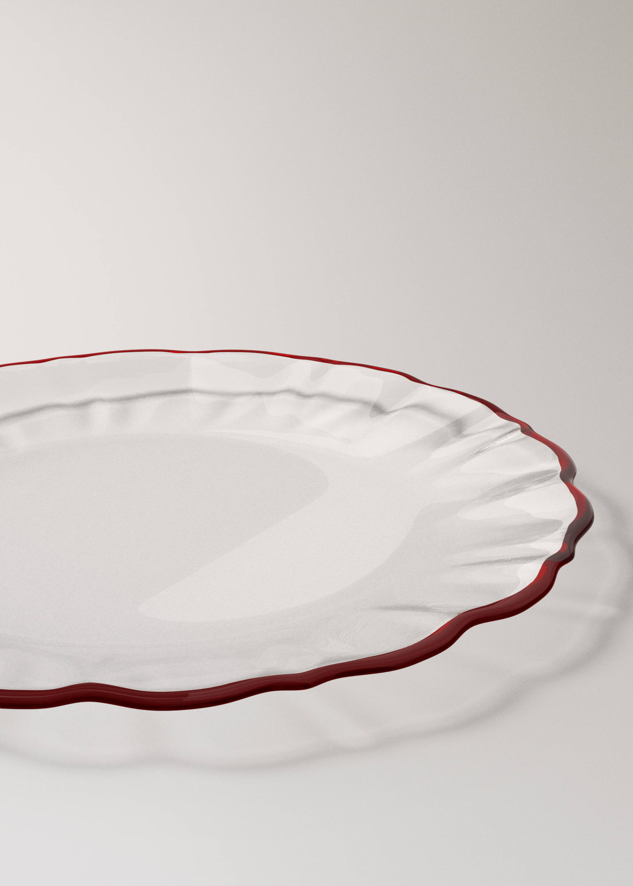 Clear glass plate with a textured rim and a red edge.