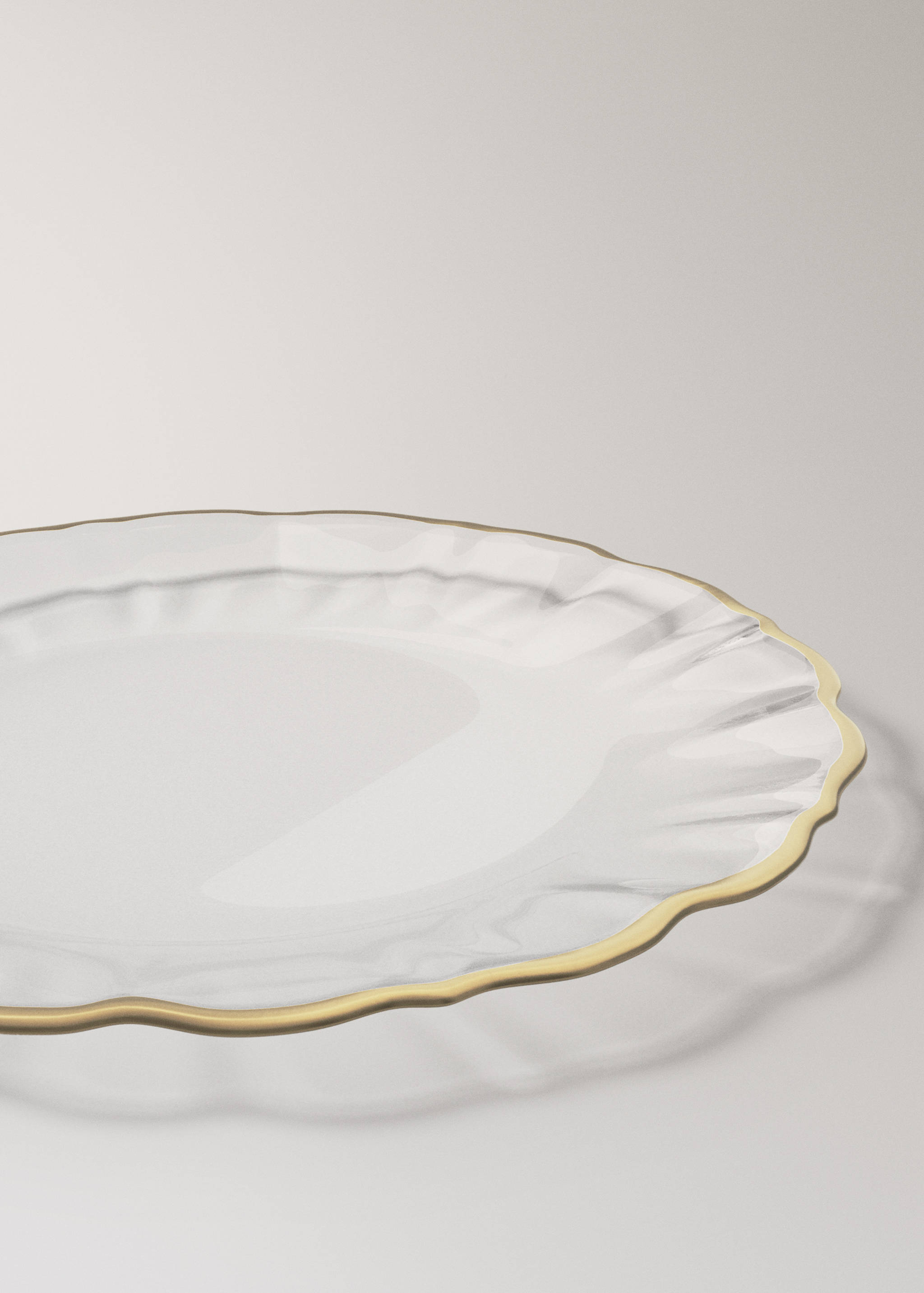 Clear glass plate with a wavy rim and gold trim.