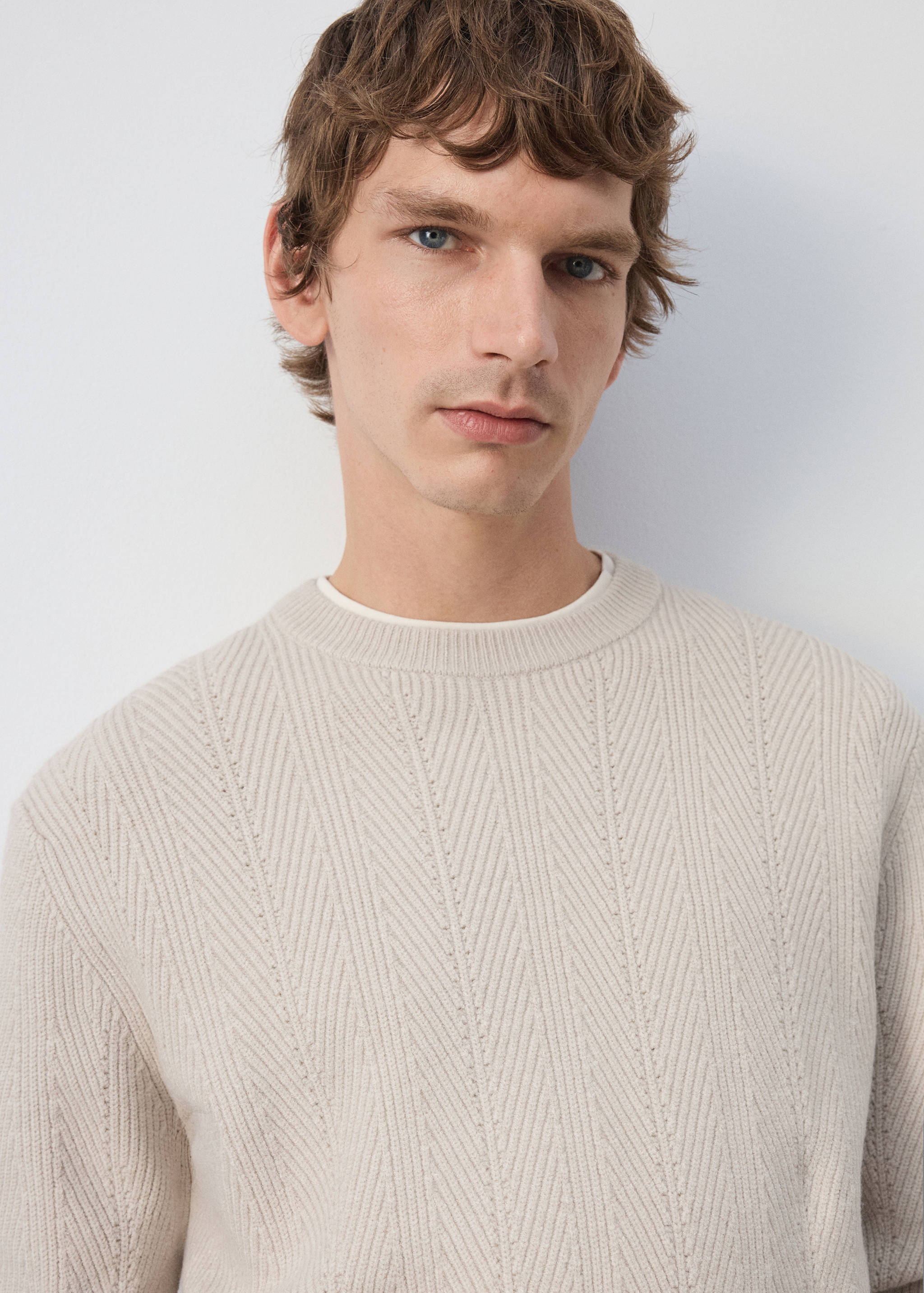 Beige knitted jersey with a crew neck and chevron-patterned detailing.