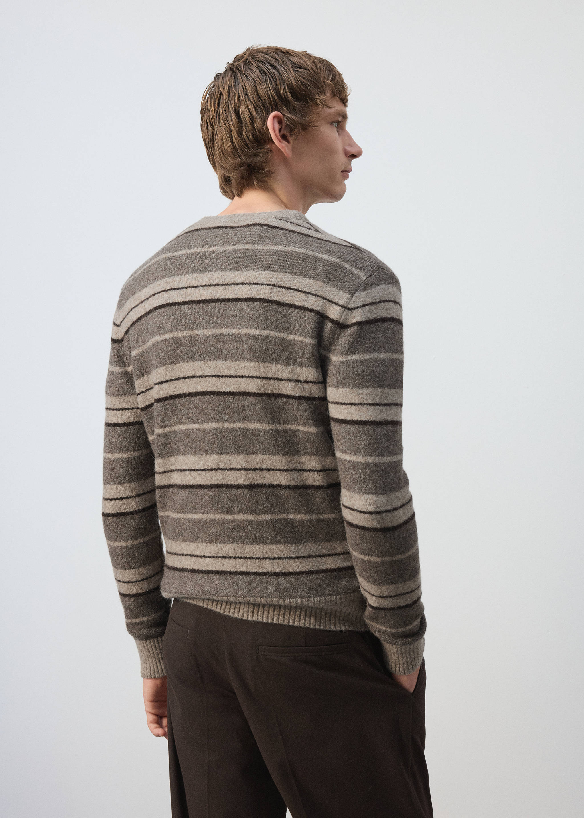 Back view of a brown striped knitted jersey with long sleeves.