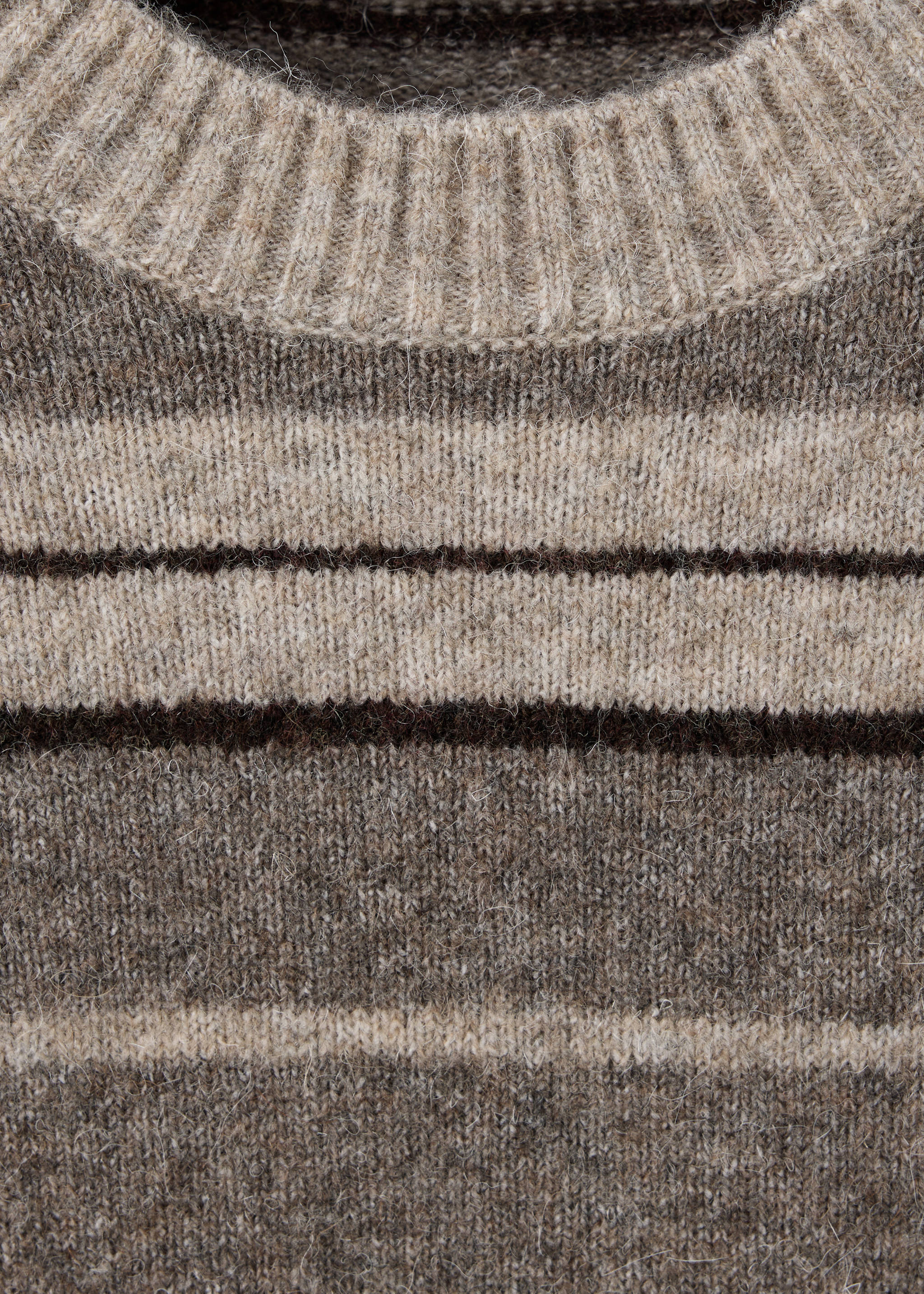 Close-up of a striped brown and beige knit sweater with a ribbed crew neck.