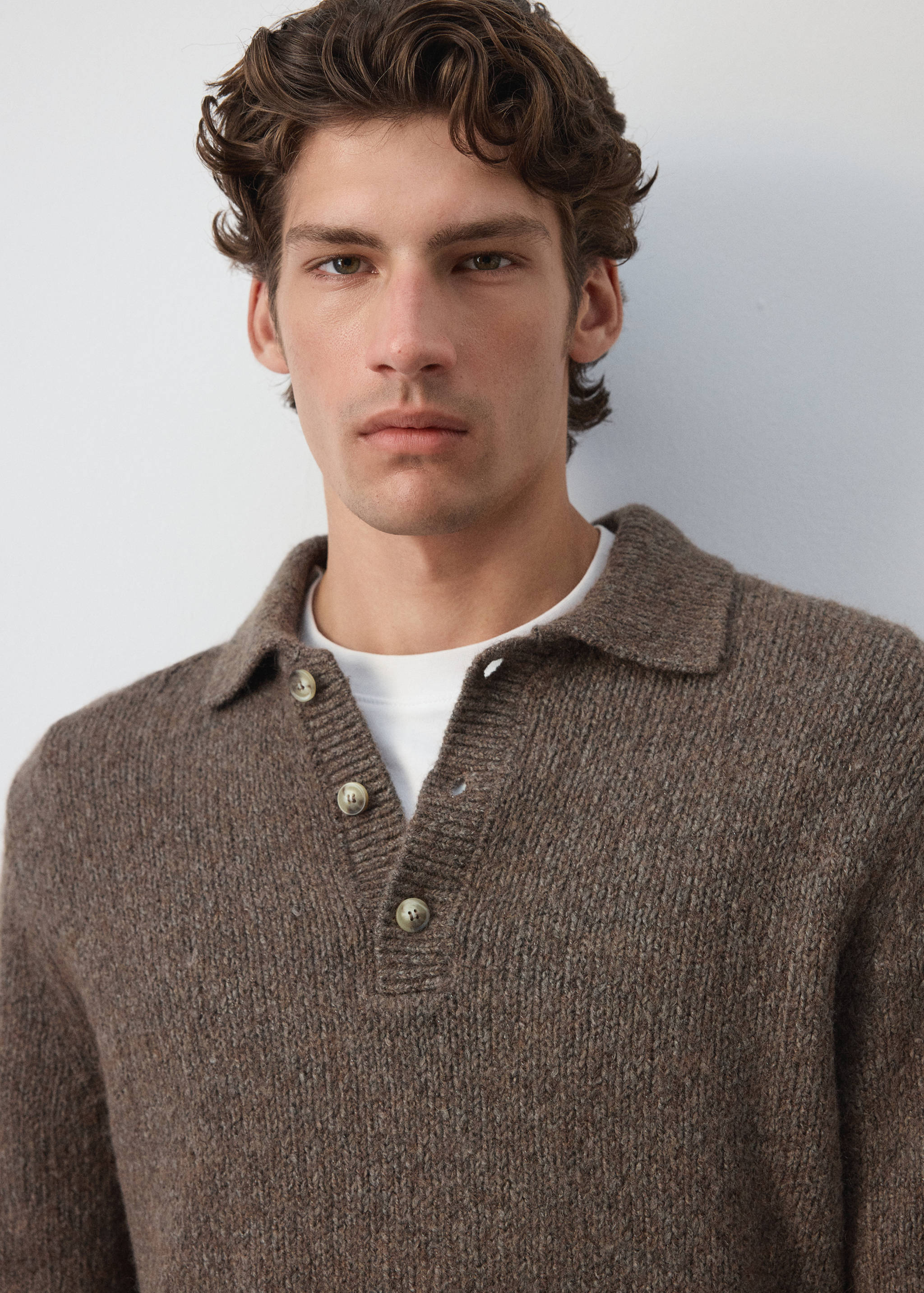 Brown knitted polo sweater with a collar and buttoned placket.