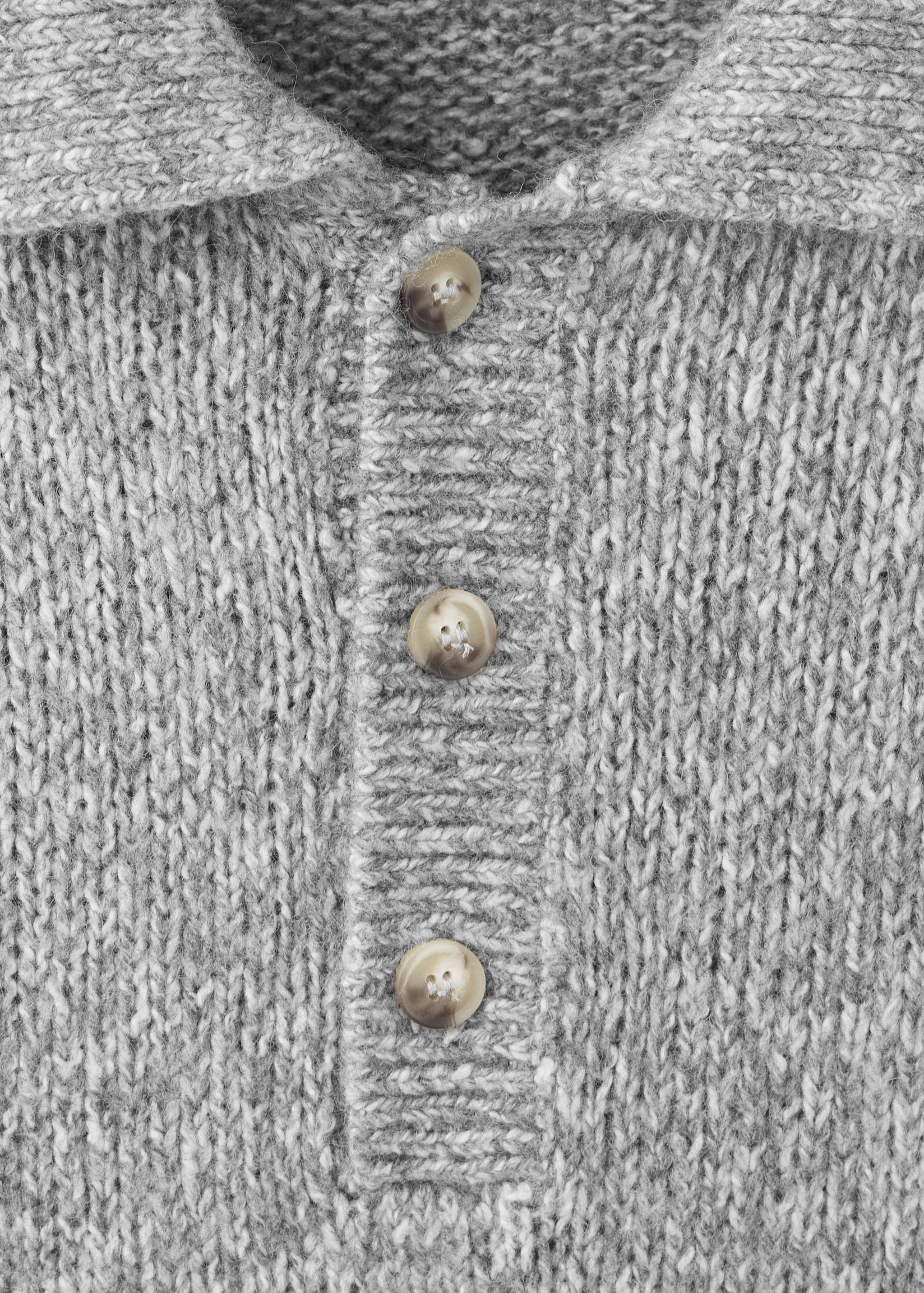 Close-up of a grey knitted polo shirt with a button placket and collar.