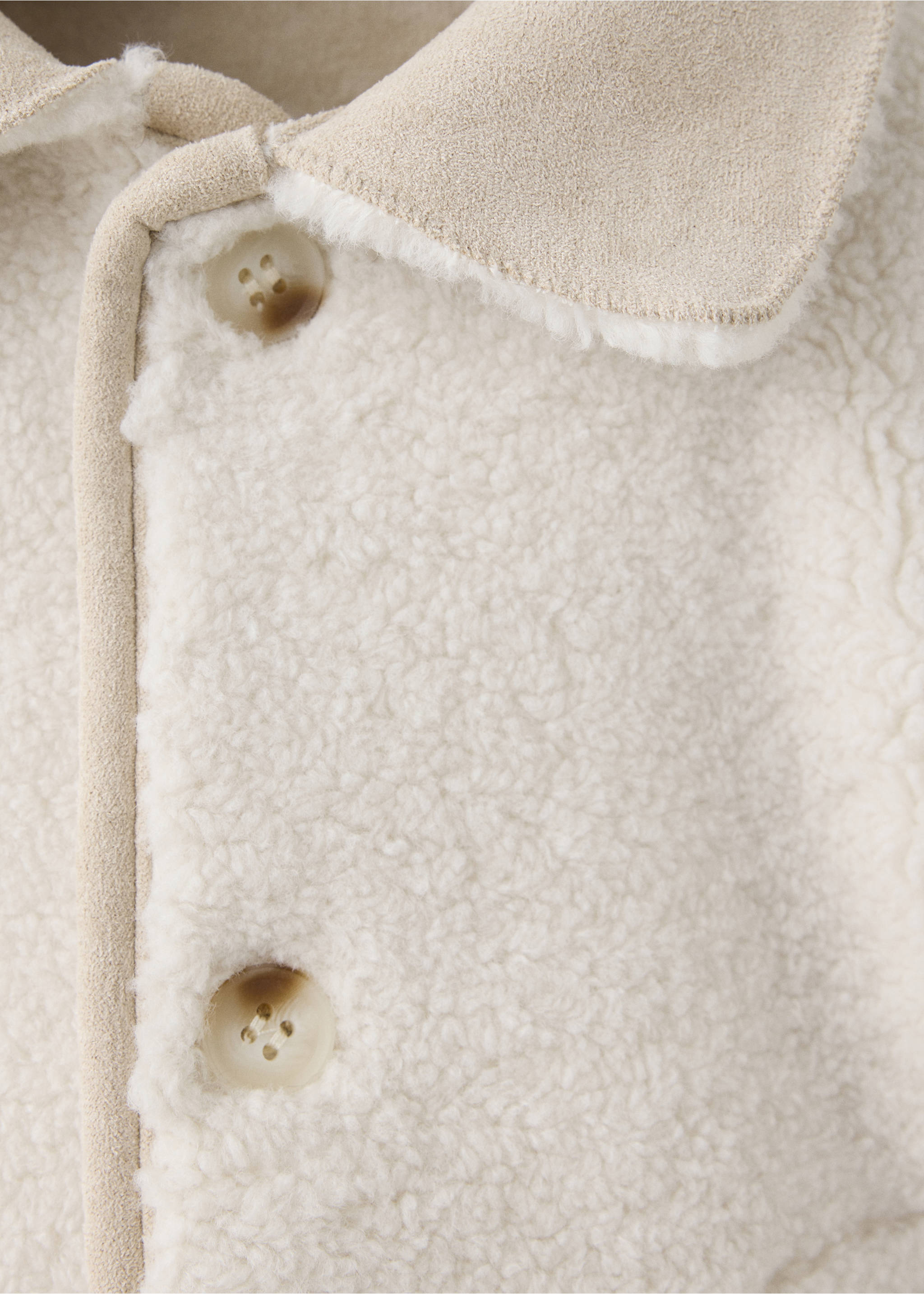 Close-up of an off-white fleece coat featuring a beige lapel collar and marbled buttons., Ecru. Ref: 37027928-00.
