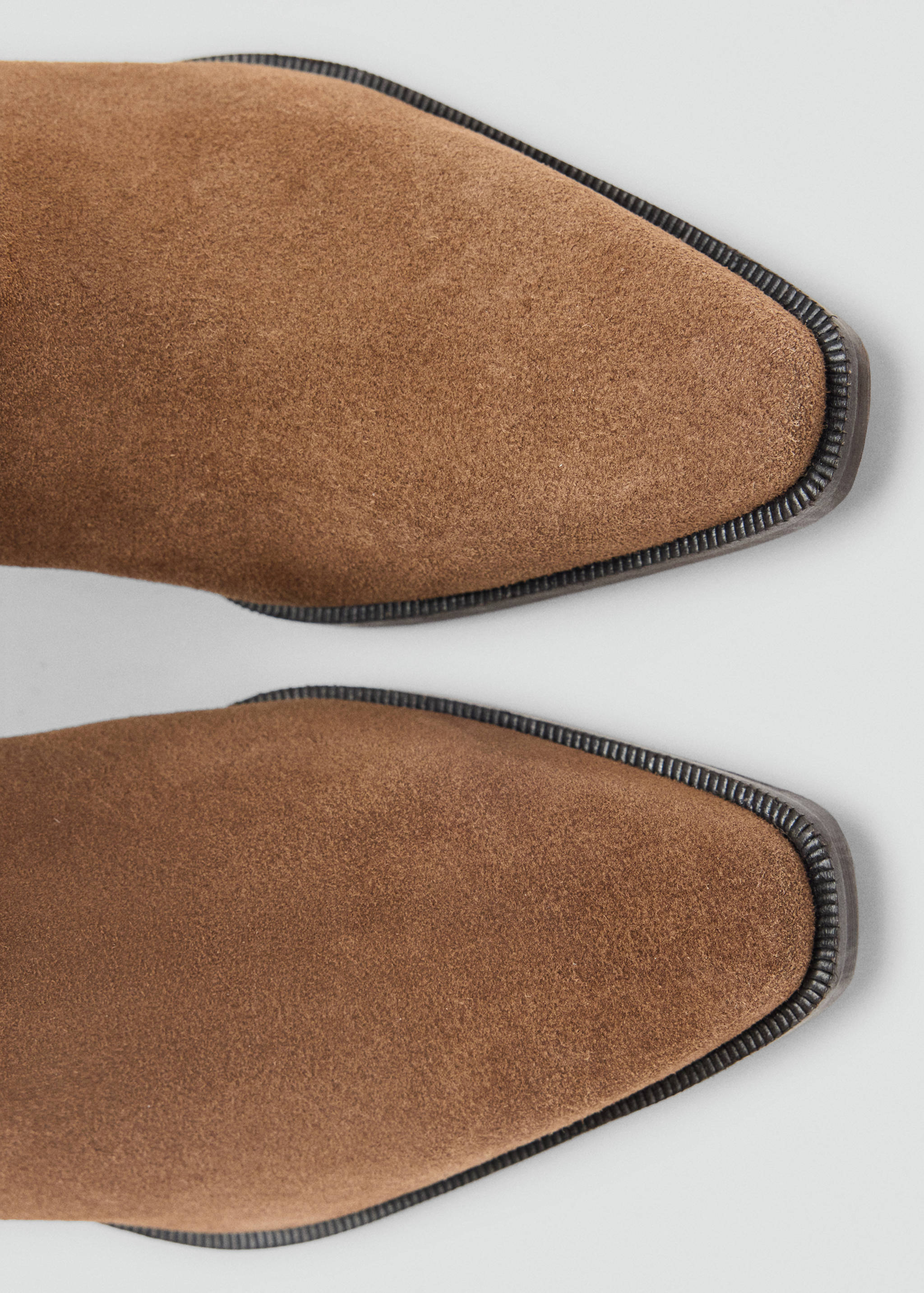 Brown suede boot toe detail with pointed design.