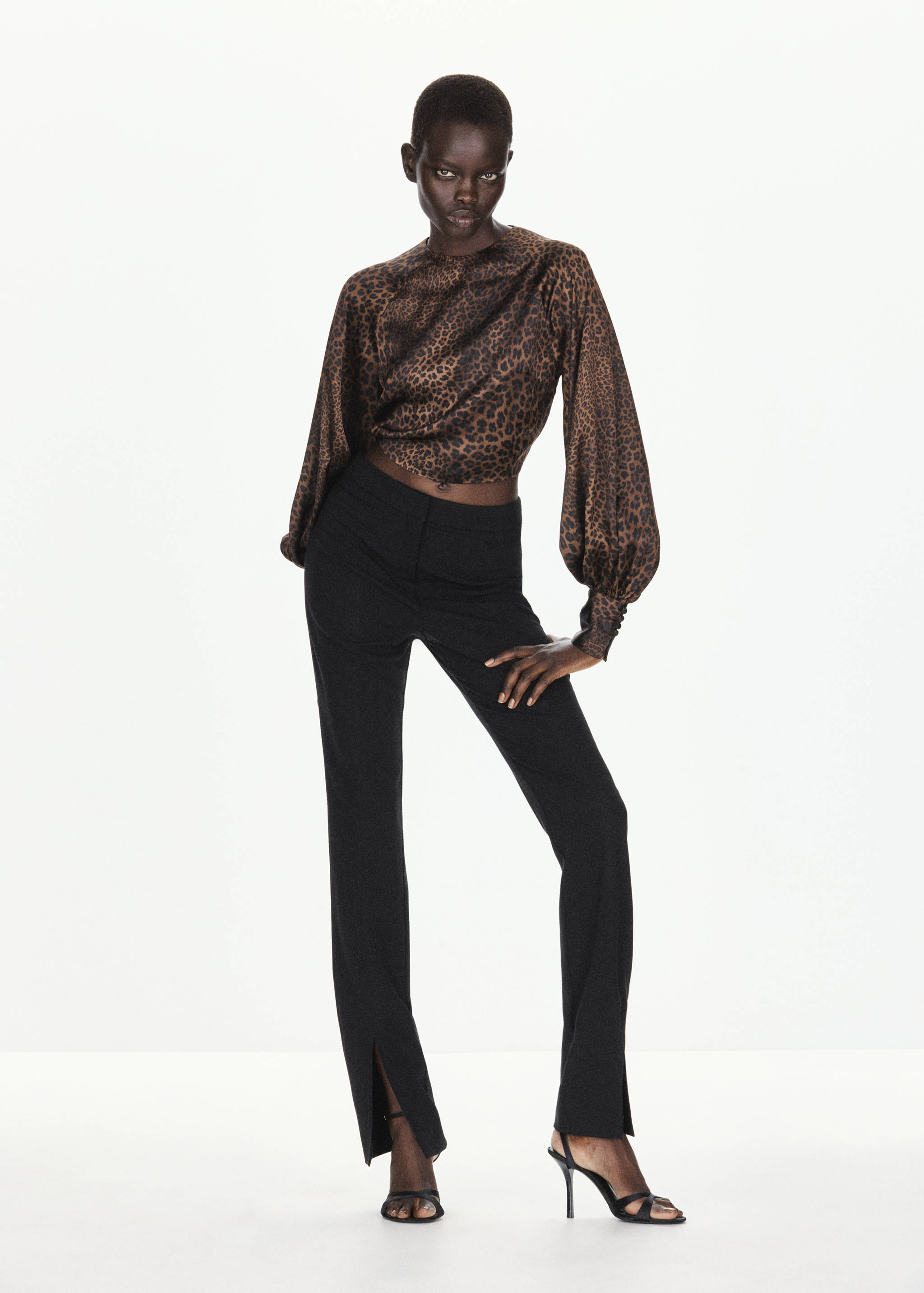 Leopard print cropped blouse with long balloon sleeves, worn with black trousers.