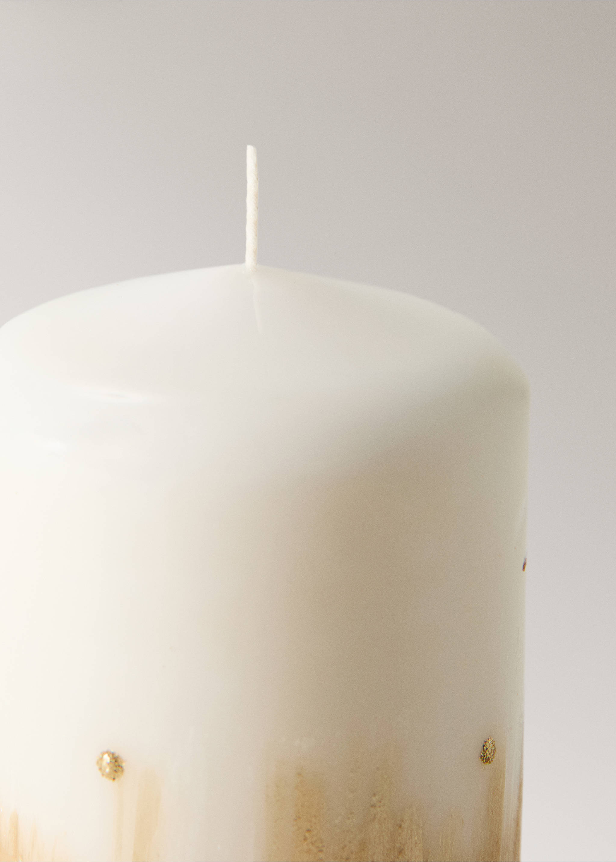 Close-up of an off-white pillar candle with gold decorative details., Gold. Ref: 37027942-00.