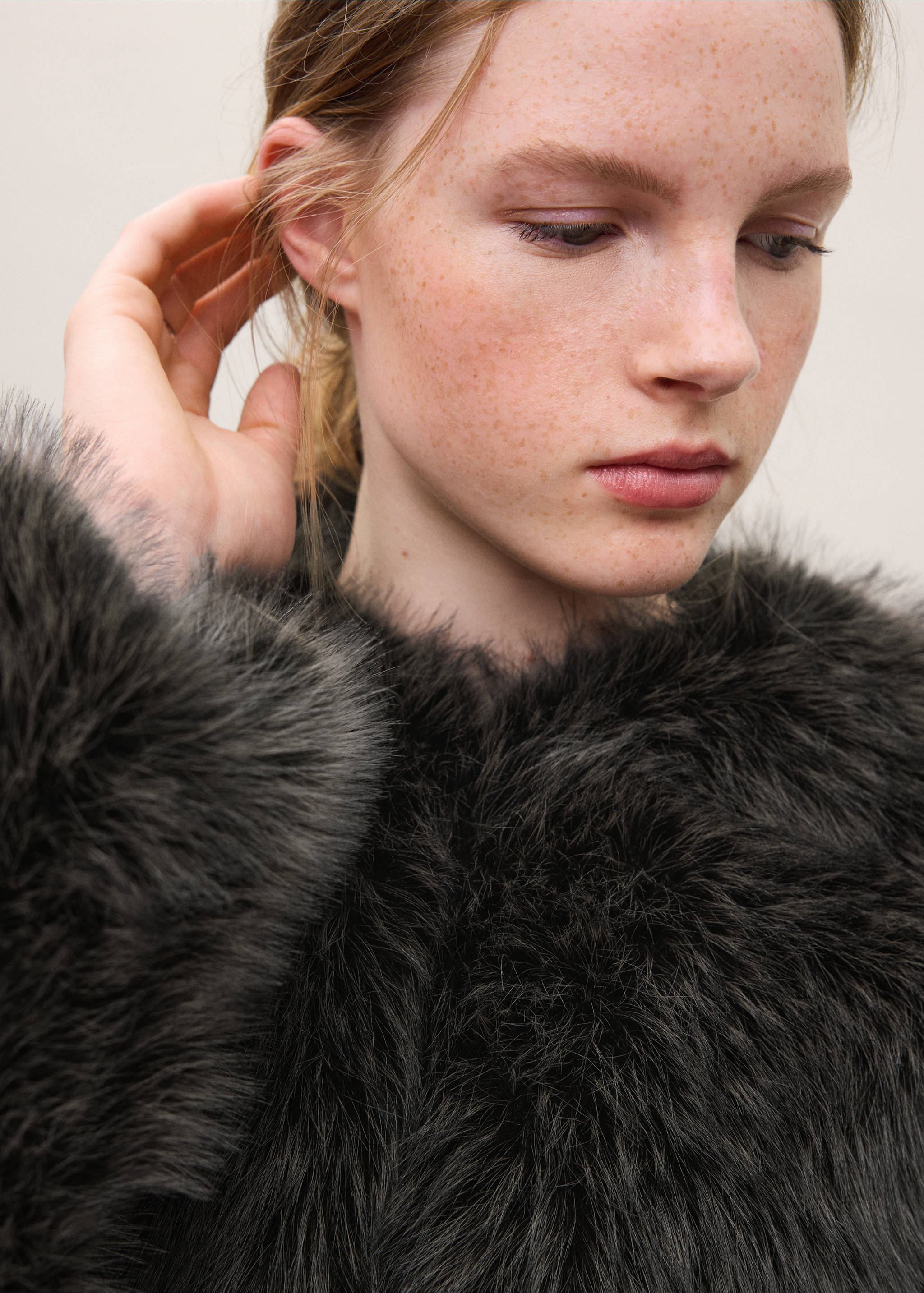 Close-up of a model wearing a dark grey textured faux-fur coat., Black. Ref: 37028265-00.