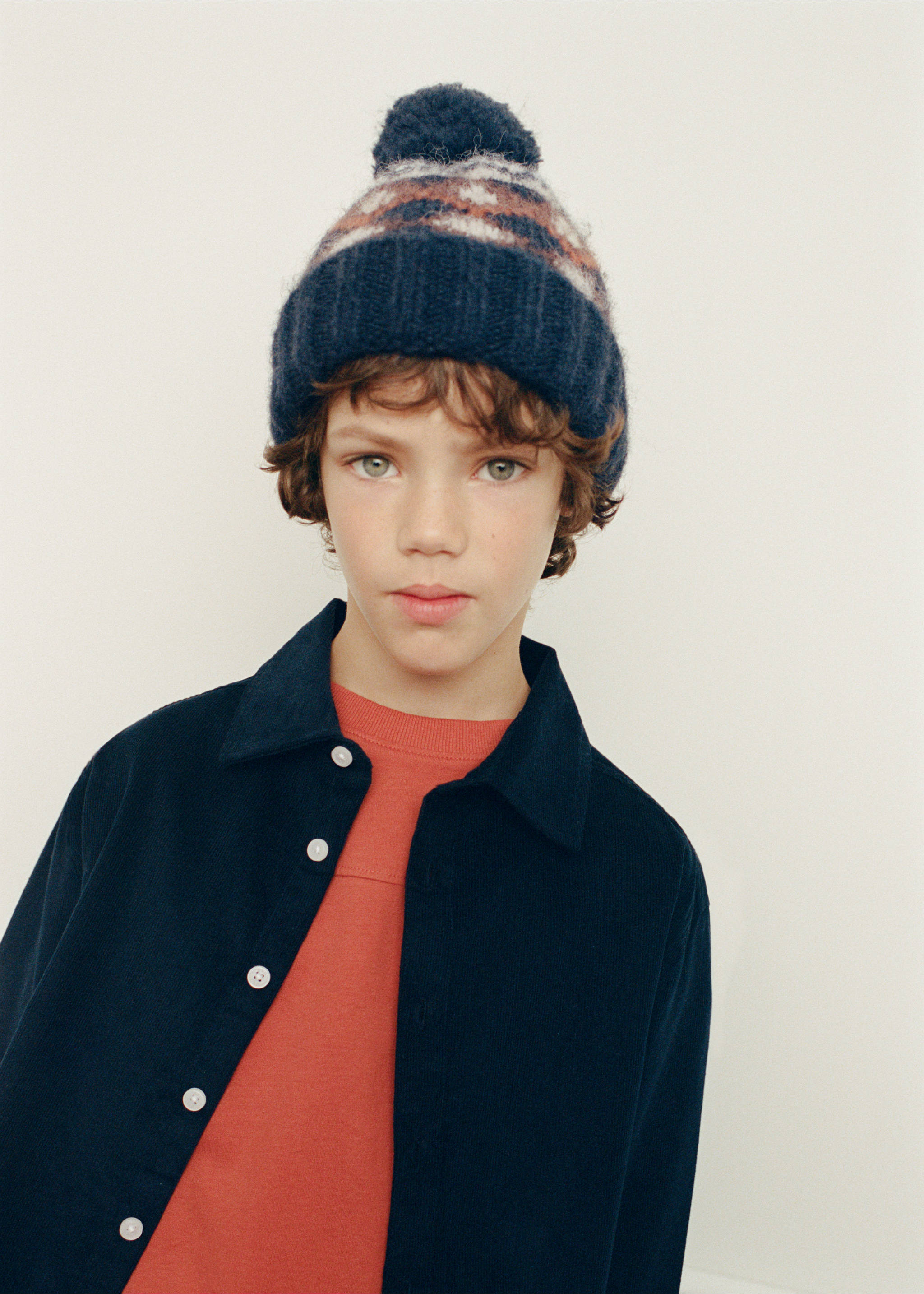 Navy blue knitted beanie with a pom-pom, ribbed cuff, and geometric patterned band., Navy. Ref: 37028267-00.