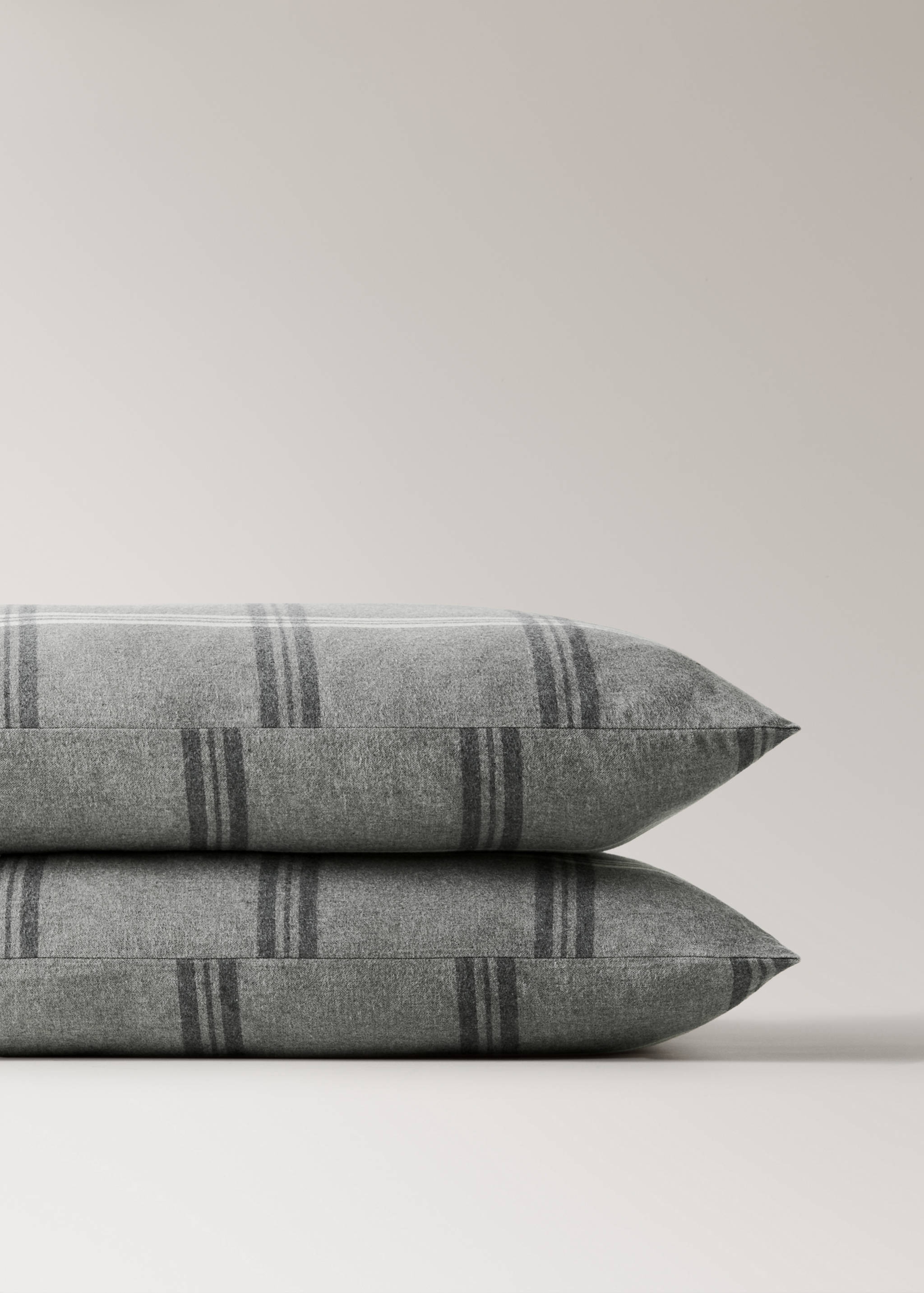 Grey flannel pillowcase with dark grey checked pattern.