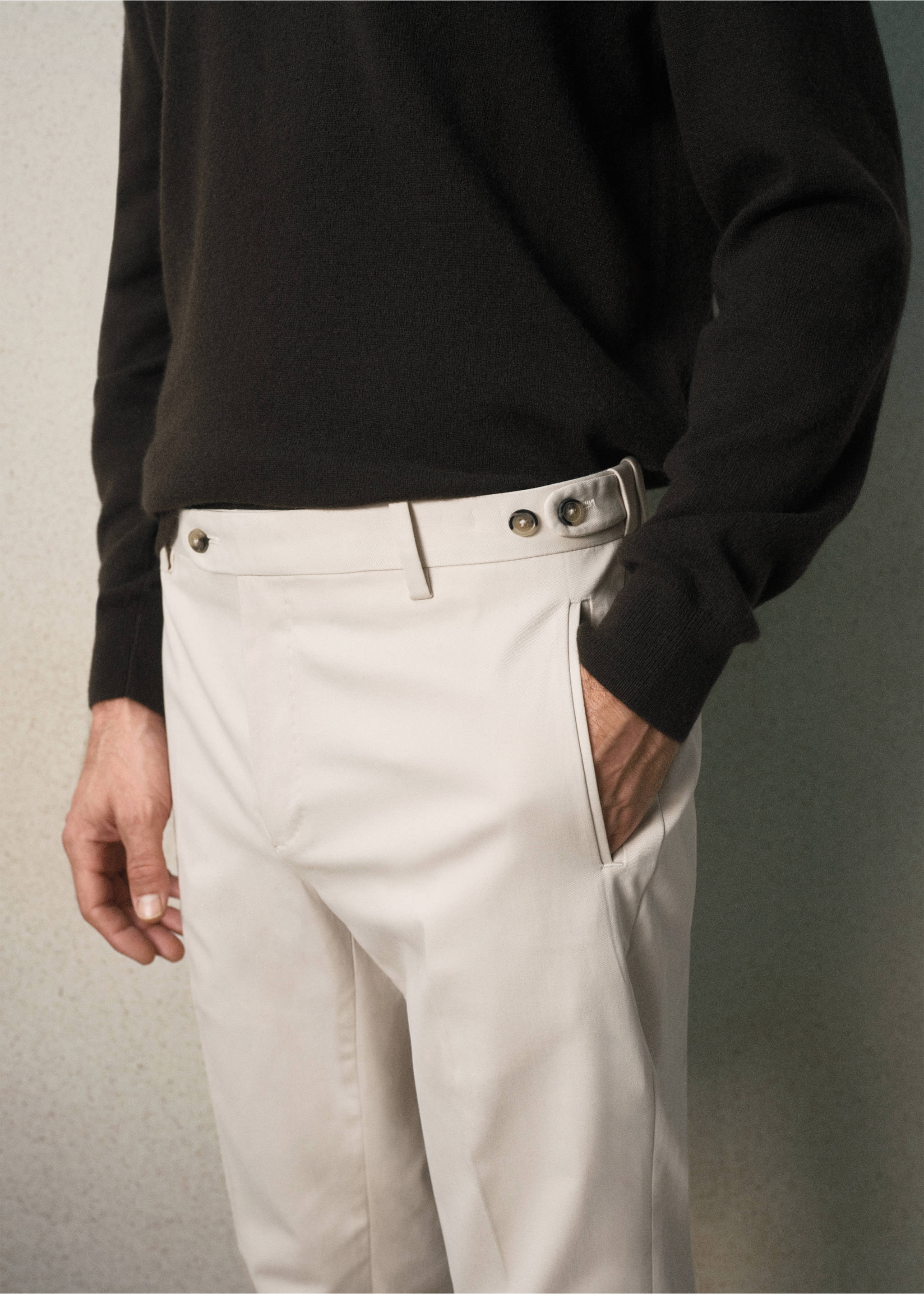 Close-up of off-white trousers with side adjusters, worn with a dark brown sweater., Beige. Ref: 37028631-00.