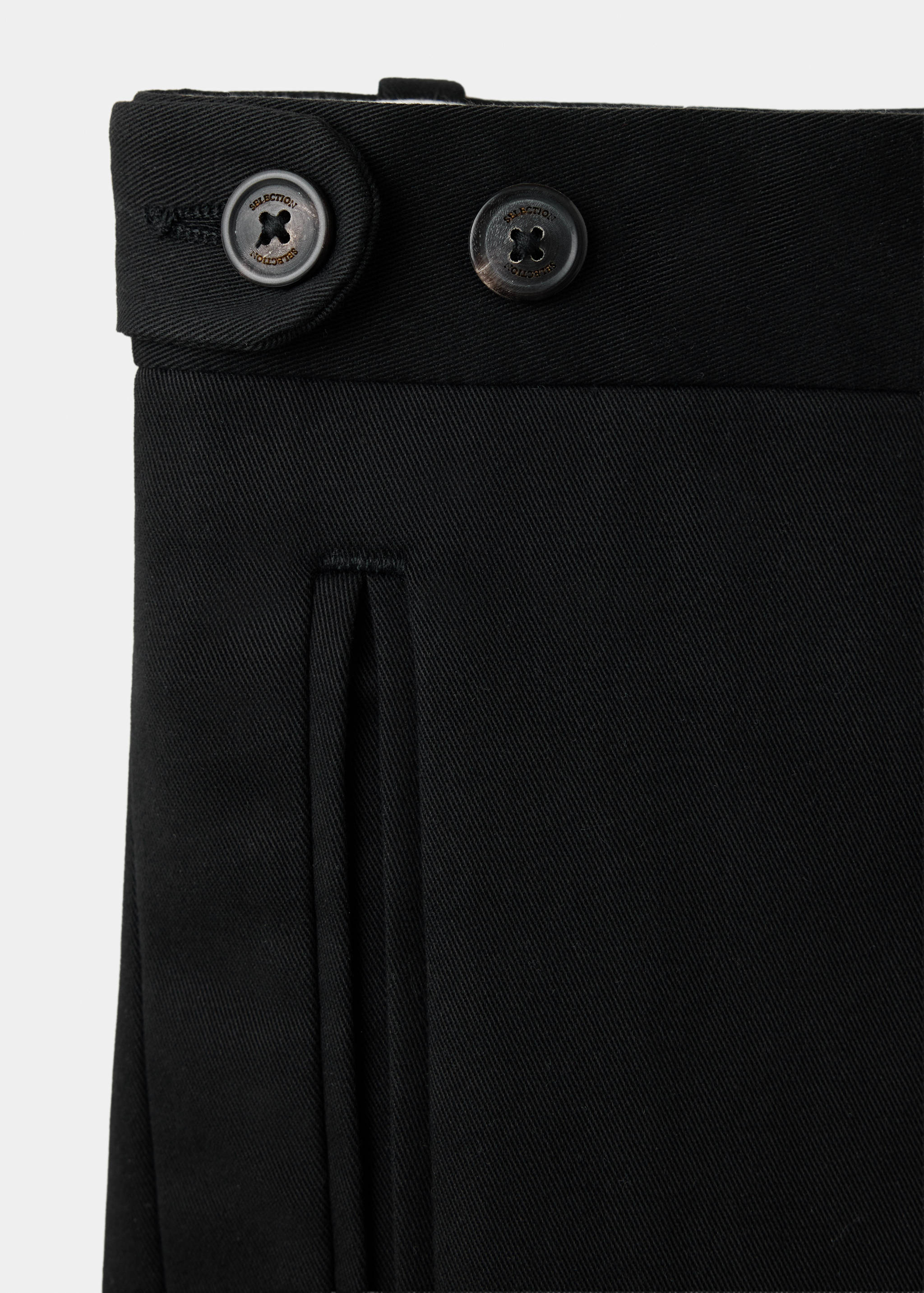 Black trousers fabric and button detail