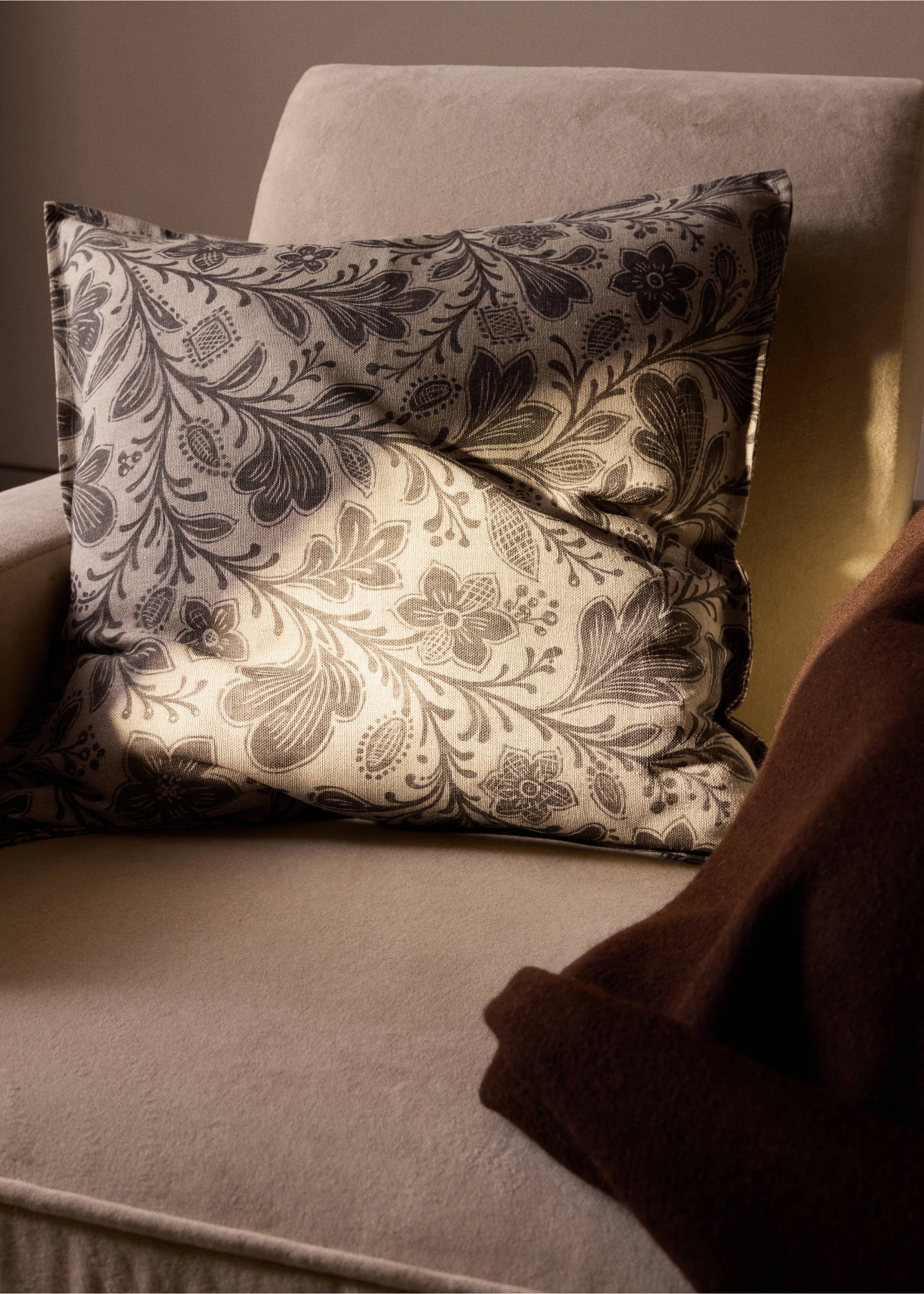 Square cushion cover with dark floral print on a light beige background resting on an armchair., Grey. Ref: 37028638-00.