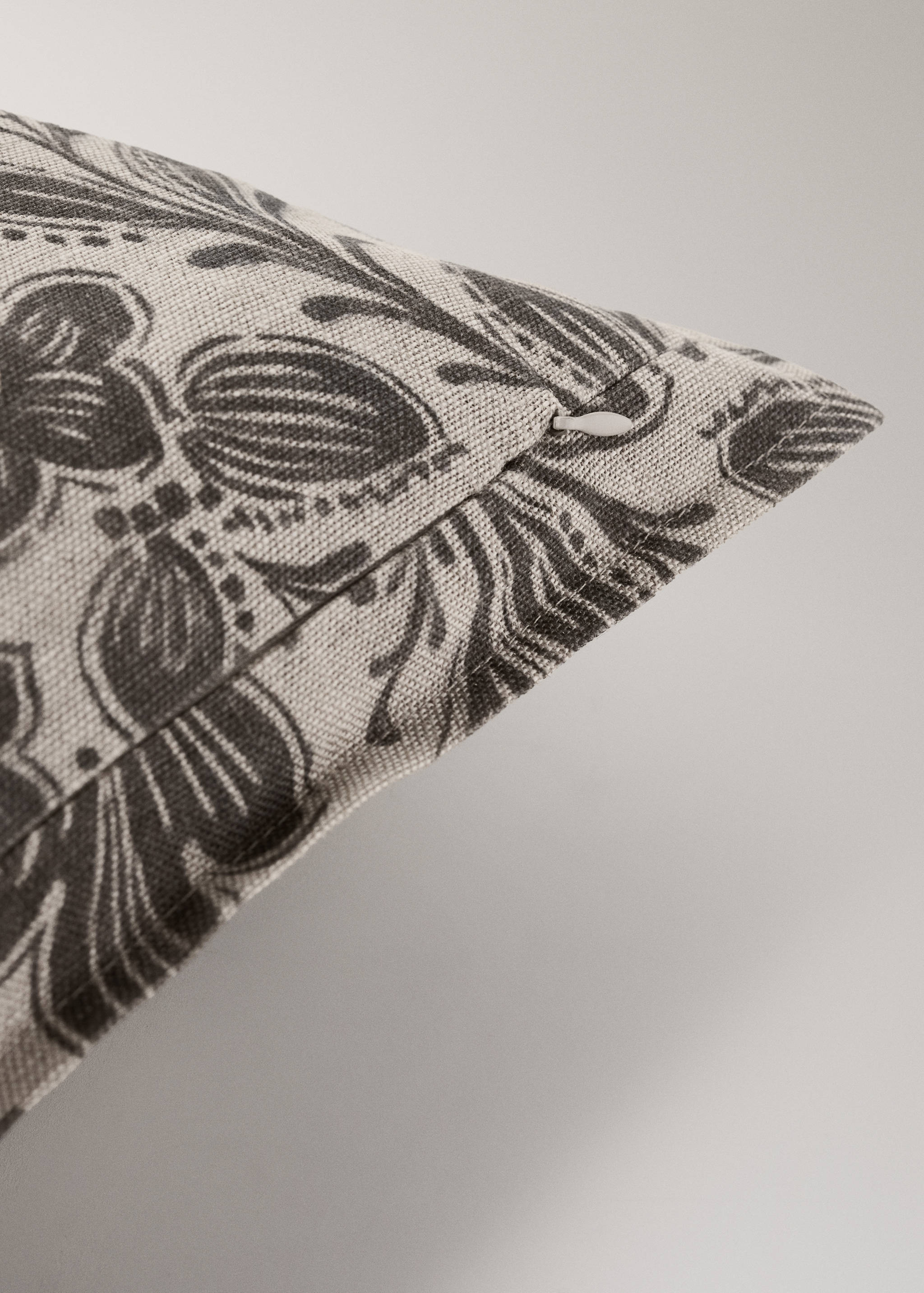 Close-up of a floral print cushion cover with a side zip detail.