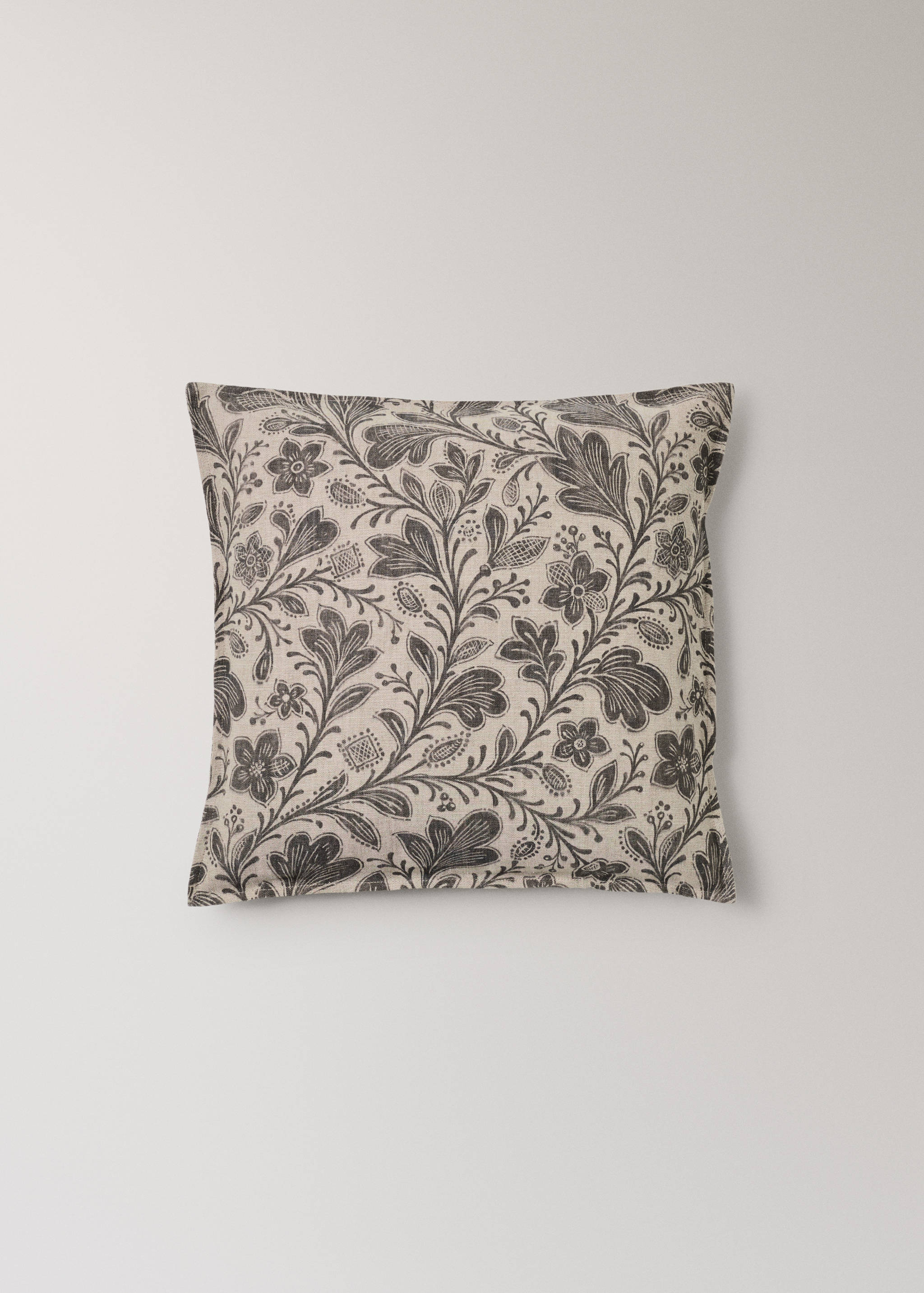 Square cushion cover in light beige with a dark grey botanical print.