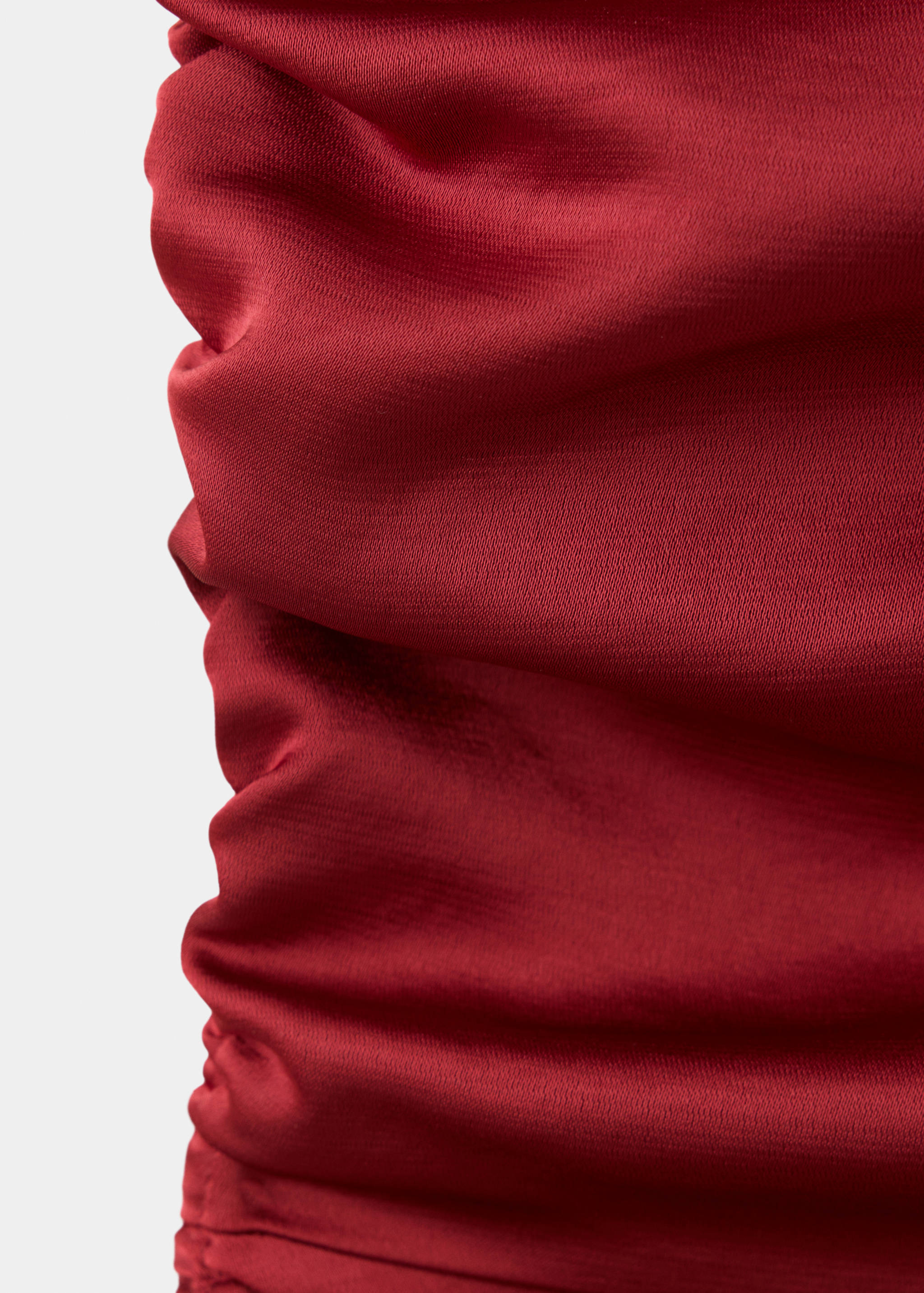 Close-up of the red dress fabric showing gathered draping texture.