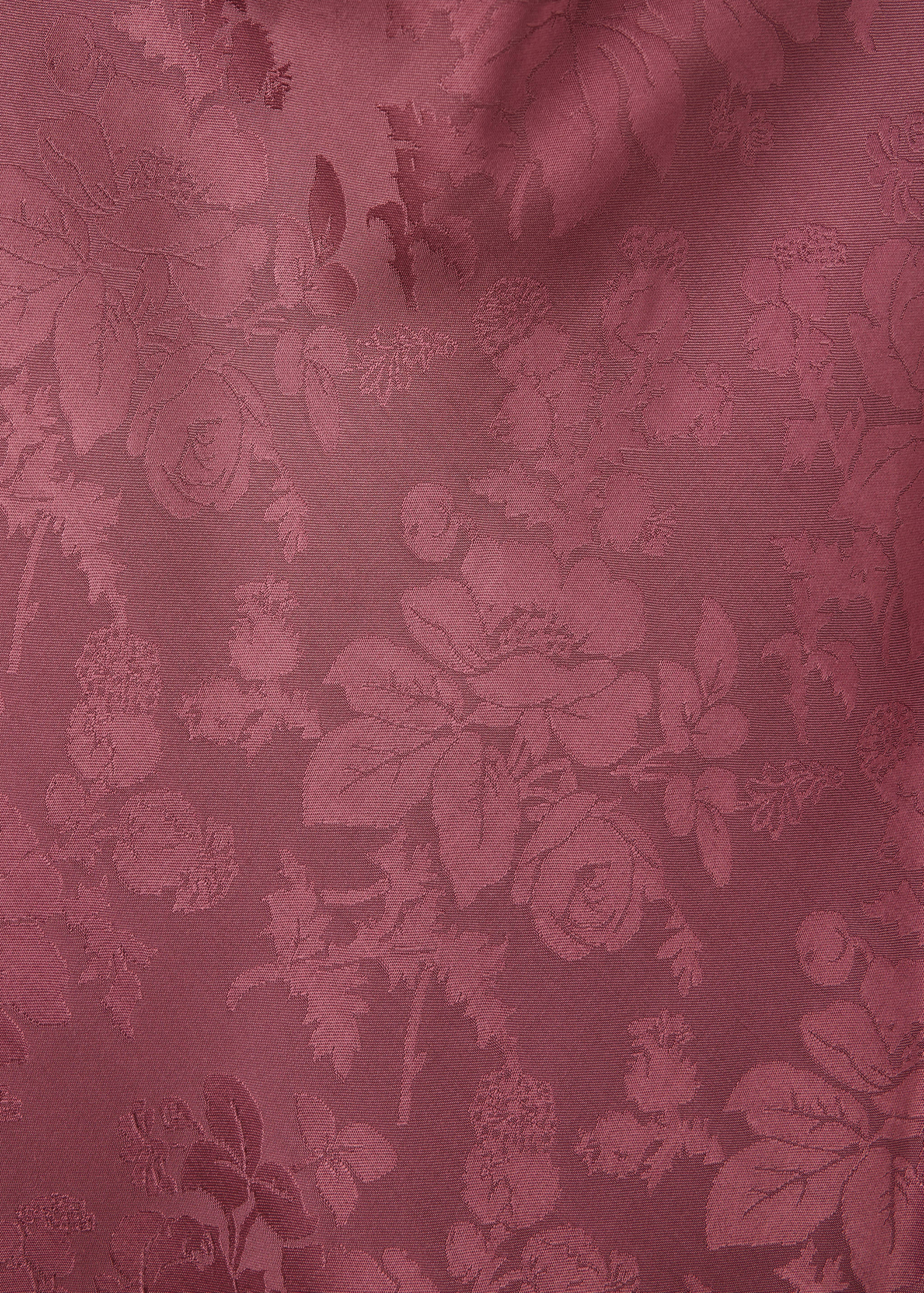 Close-up of the plum-coloured blouse fabric showing a tonal floral jacquard pattern.