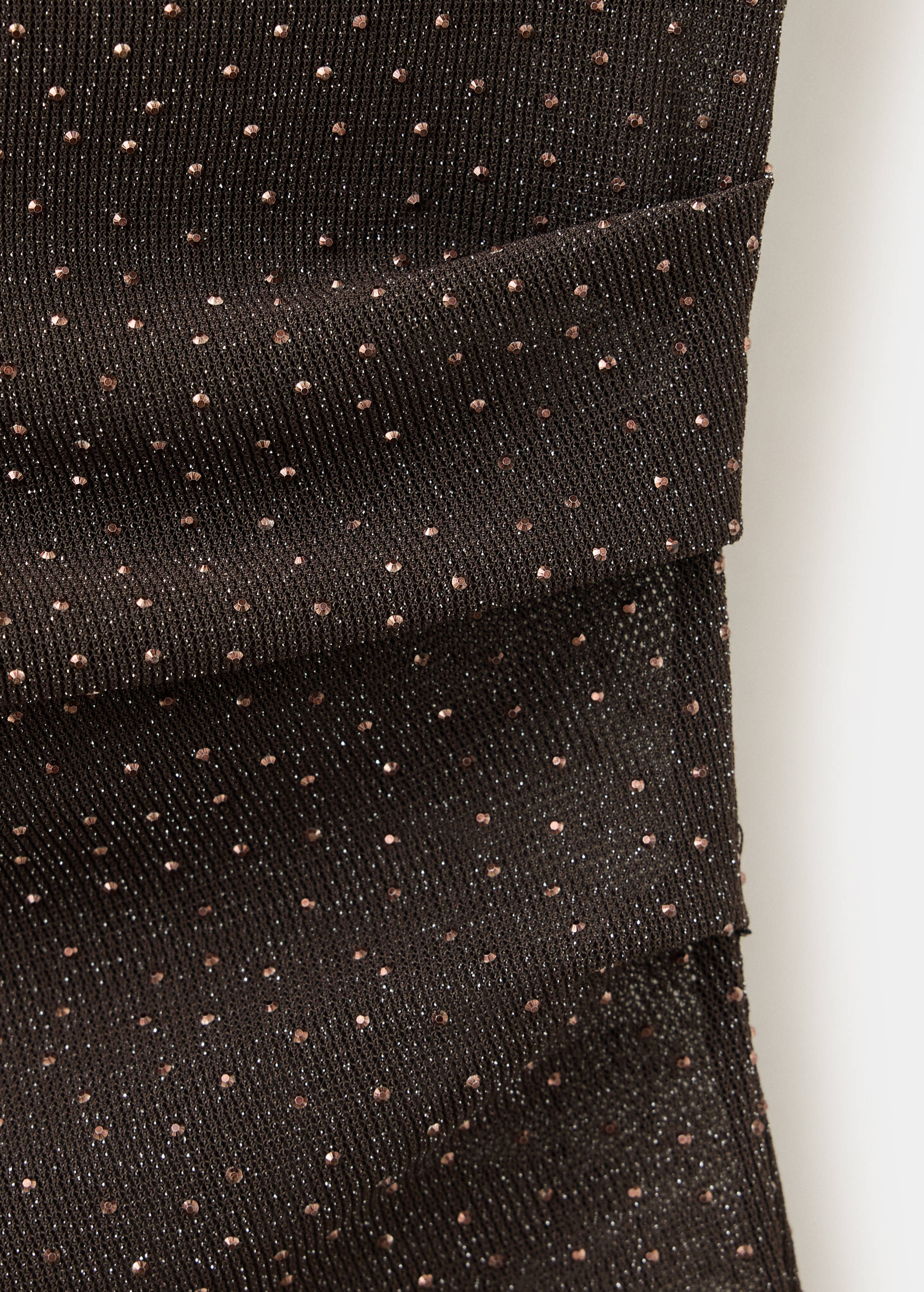 Close-up of a dark brown metallic knit top with shimmering studs.