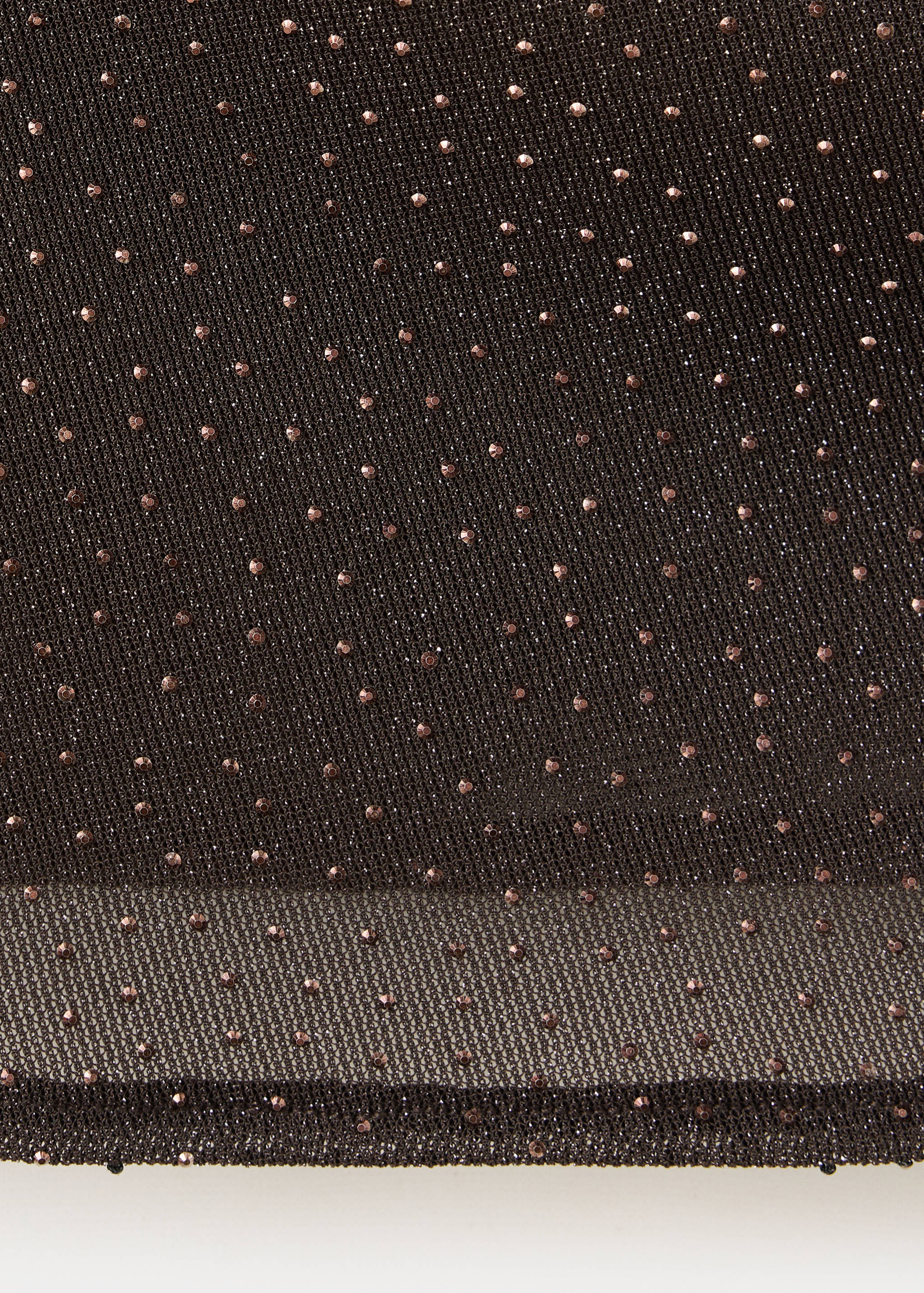 Close-up of black mesh top fabric with shimmer and copper studs.