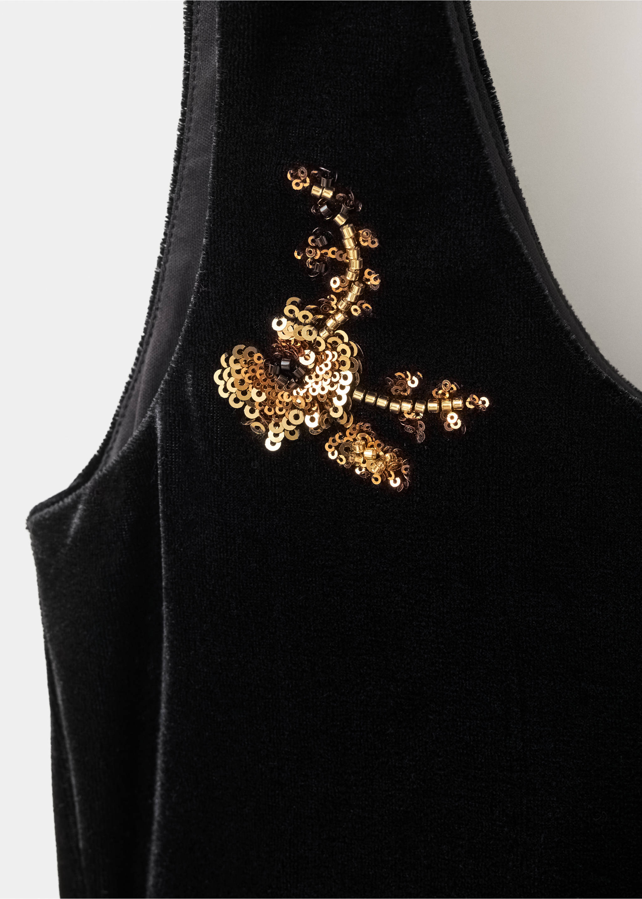 Close-up of a black velvet top with a gold sequin floral embroidery detail., Black. Ref: 37029128-00.