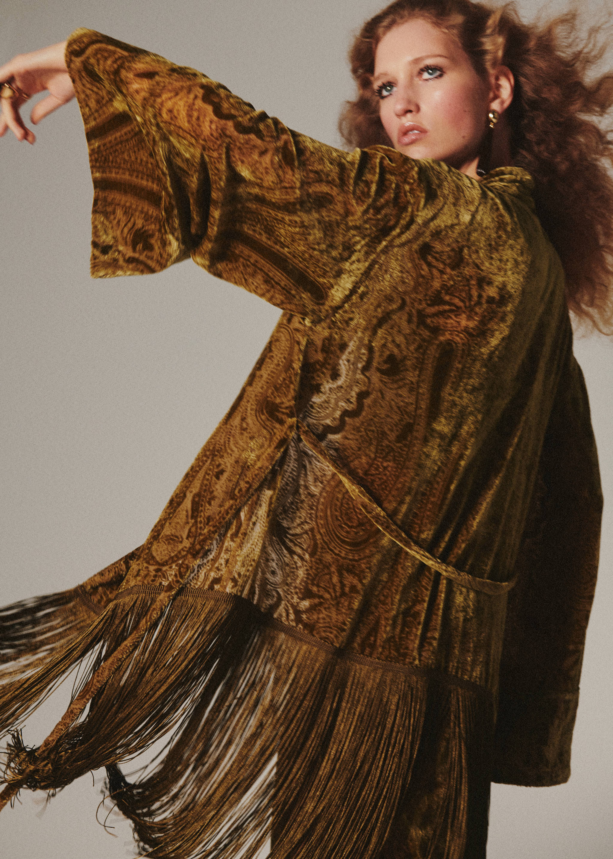 Green velvet paisley poncho with fringe, shown from the back.