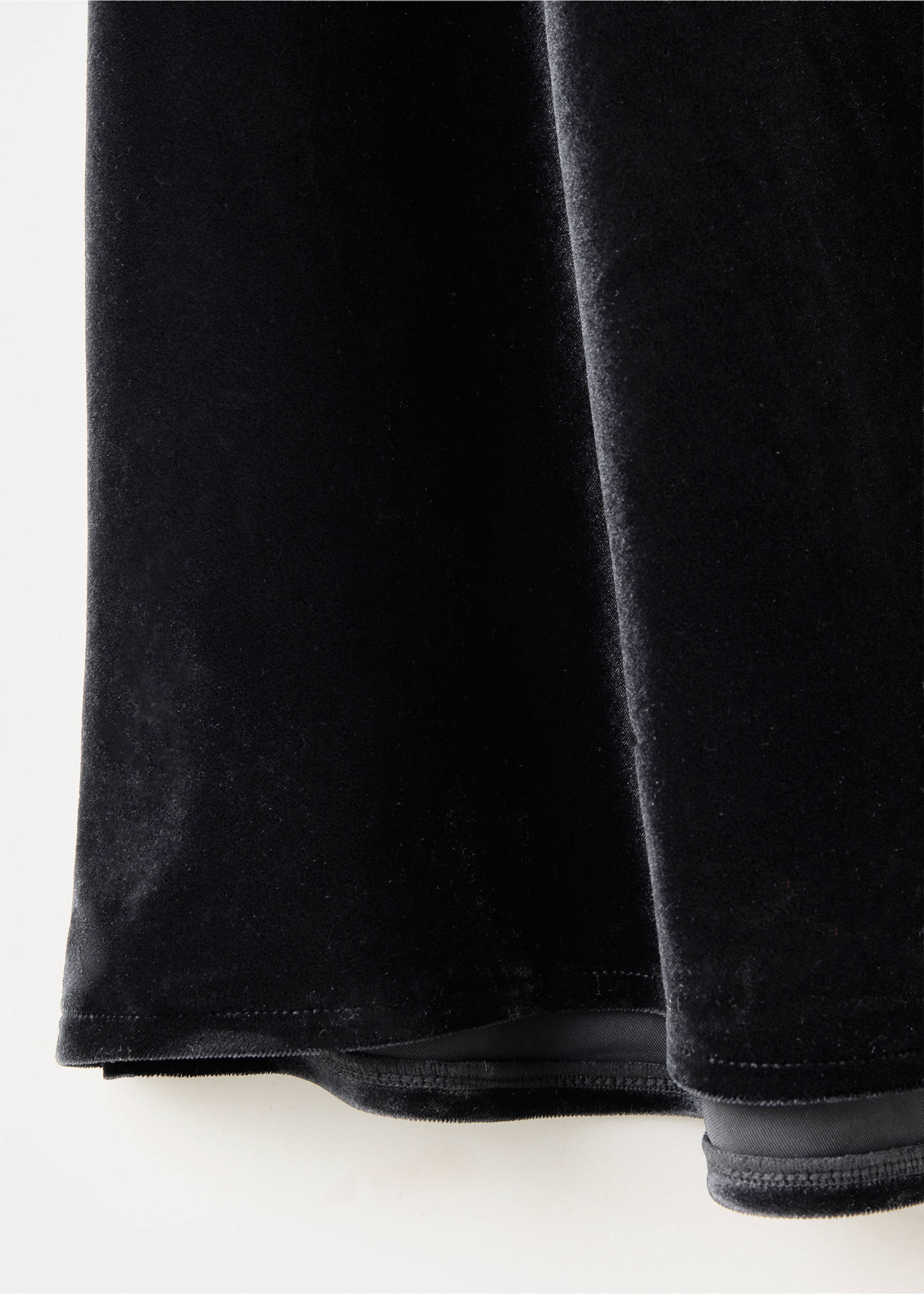 Close-up of a black velvet dress fabric showing texture and hem., Black. Ref: 37029133-00.