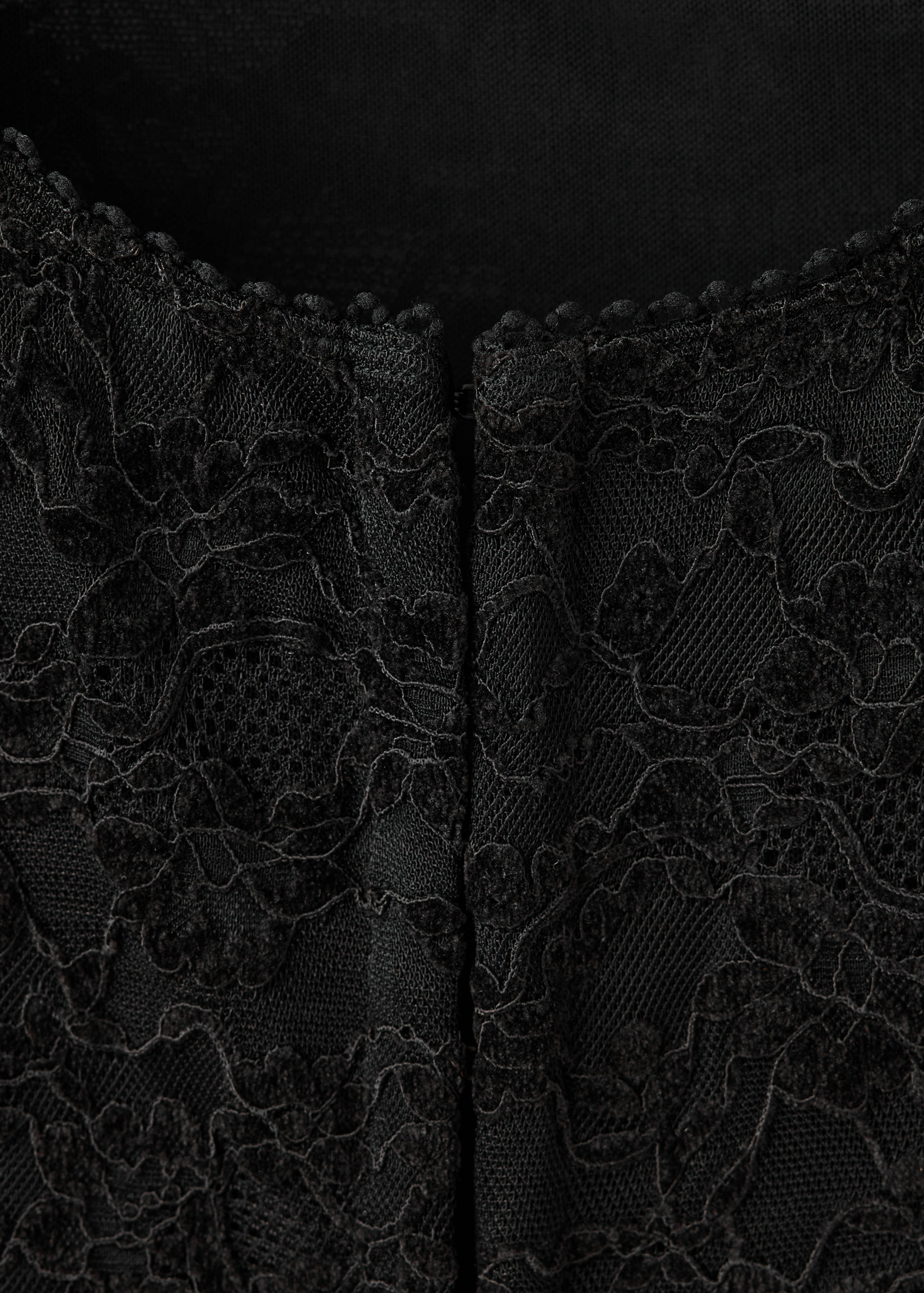 Close-up of a black lace top with a scalloped neckline.
