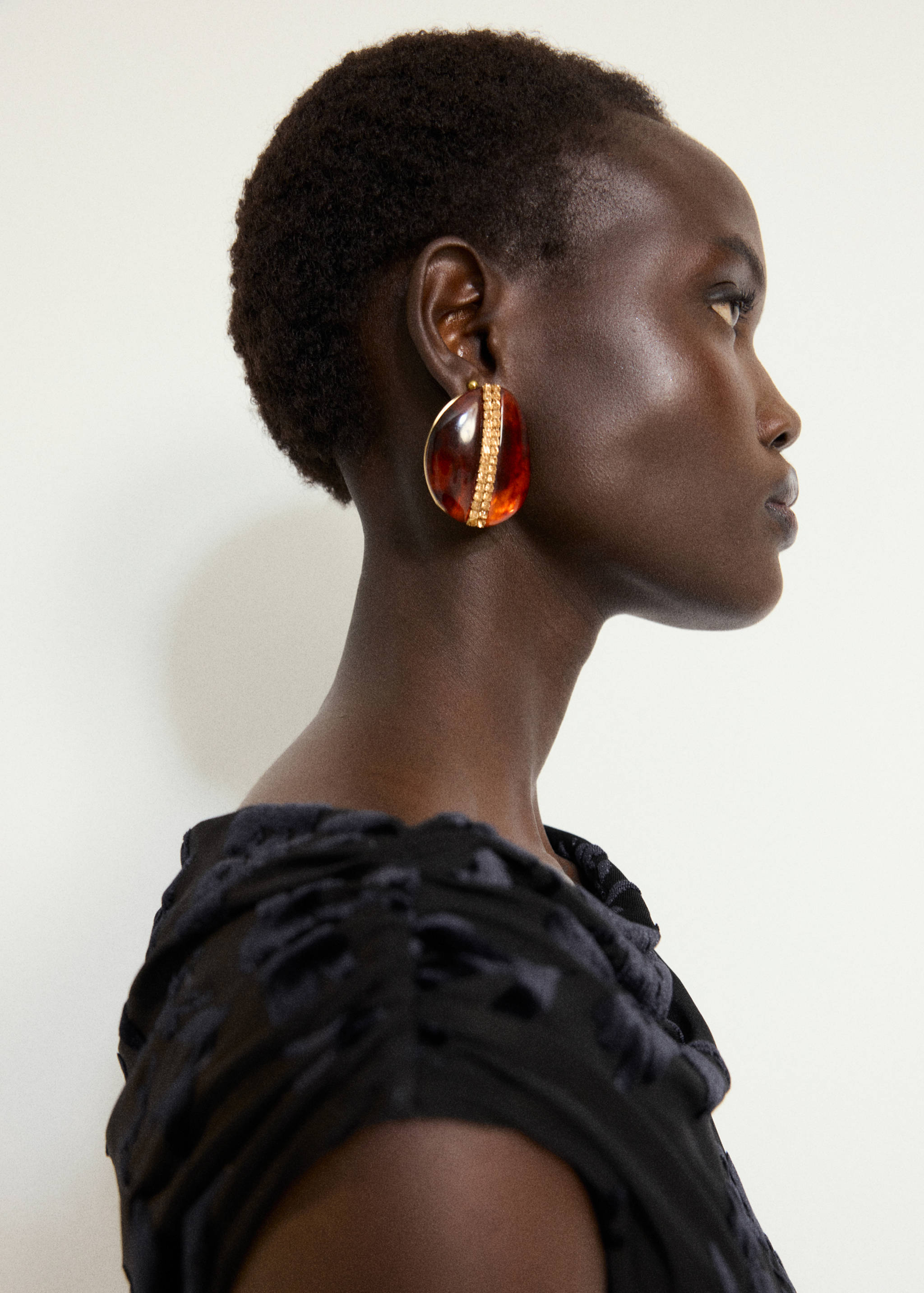 Black textured dress with a round neckline, shown in a close-up.
