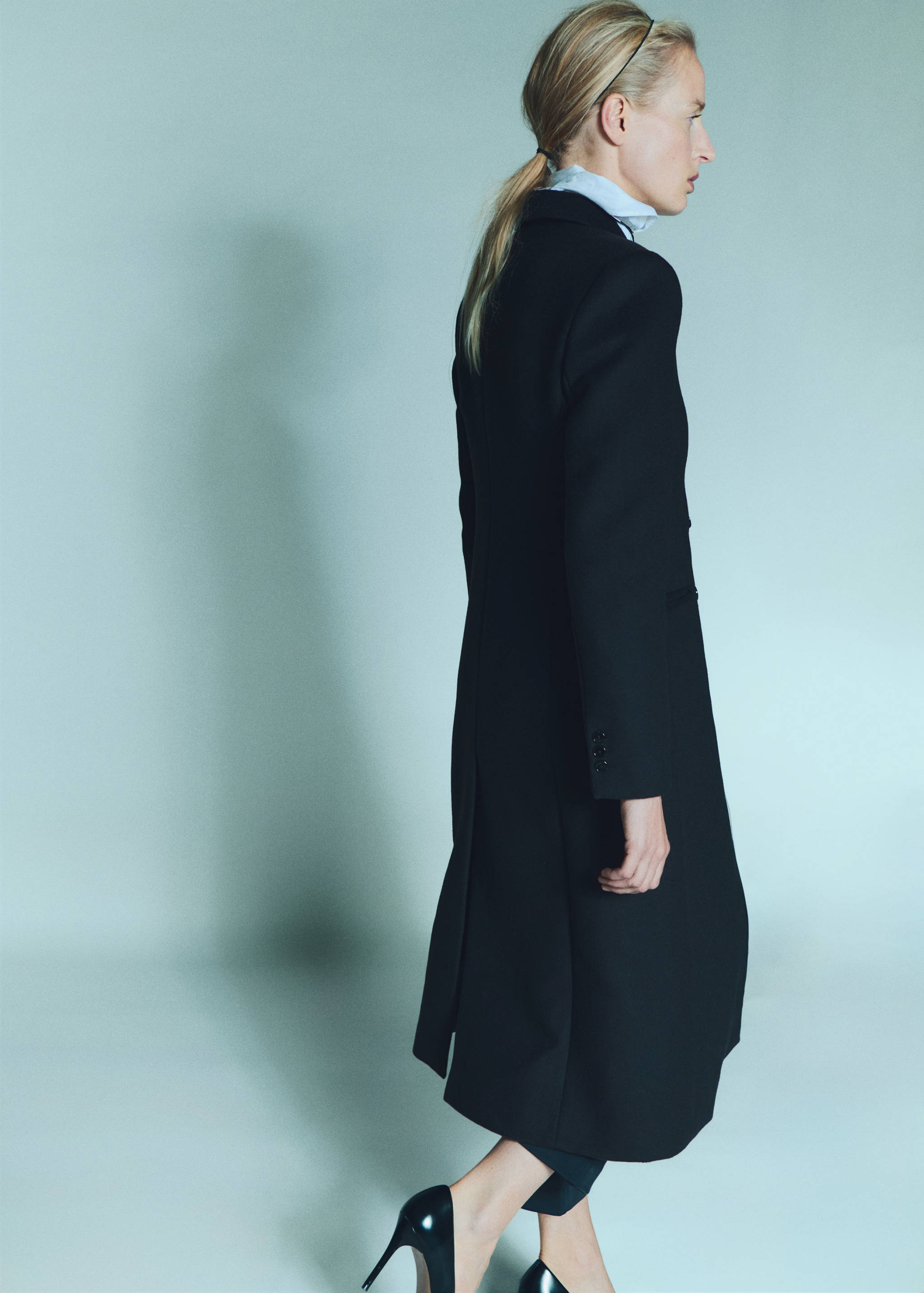 Long black tailored coat, back view.