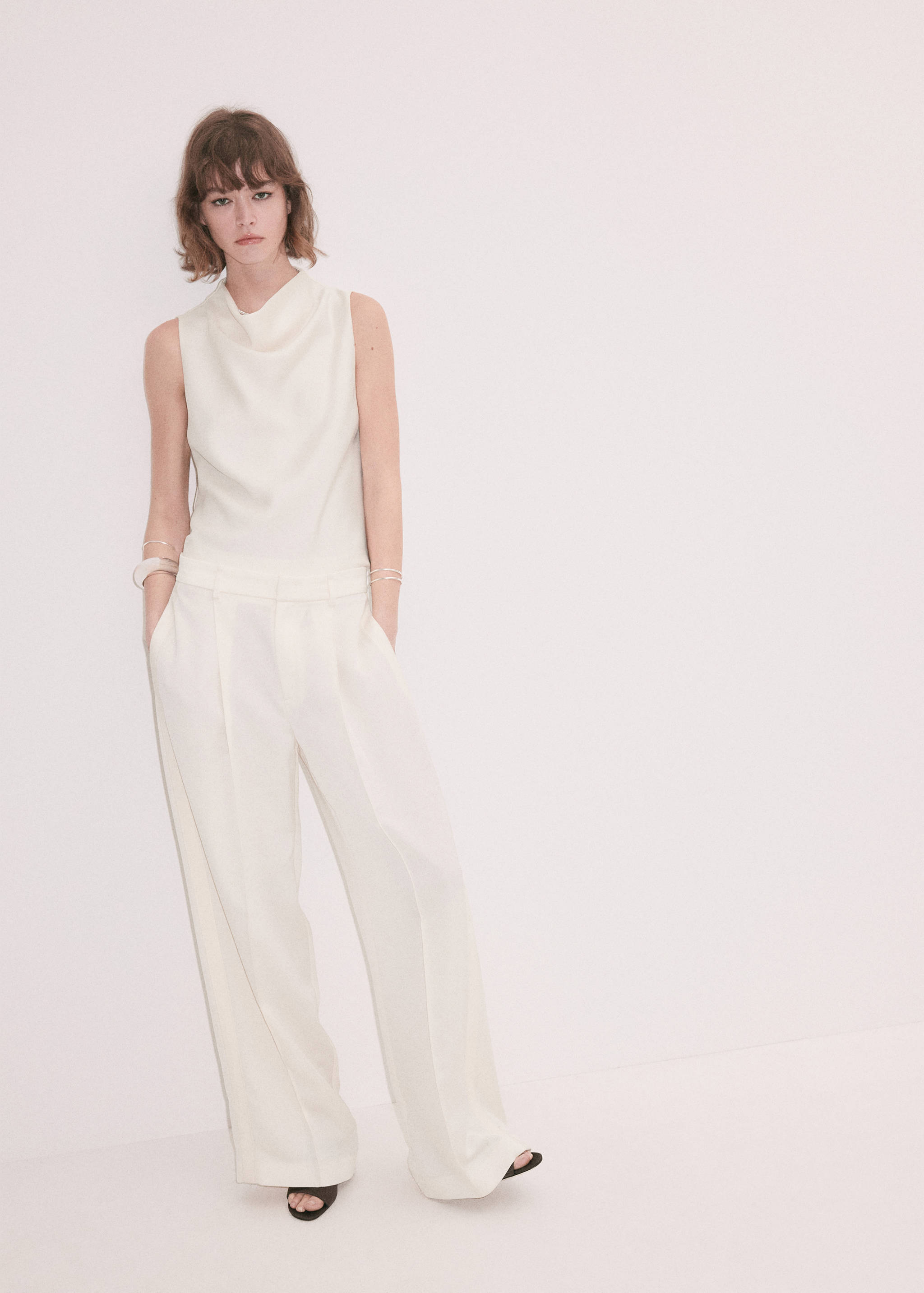 White wide-leg pleated trousers with a structured waistband.