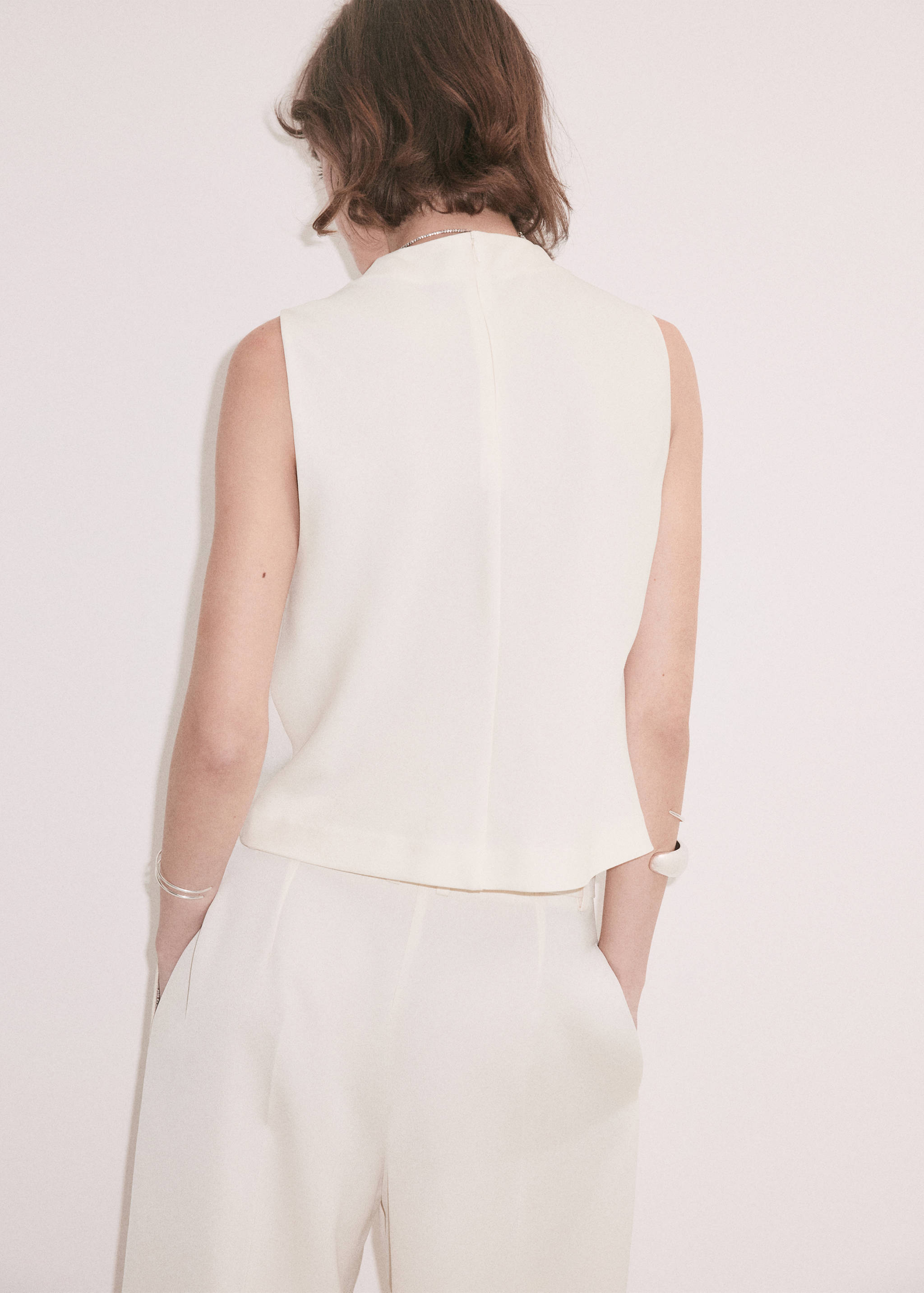 White trousers, shown from the back on a model wearing a matching top.