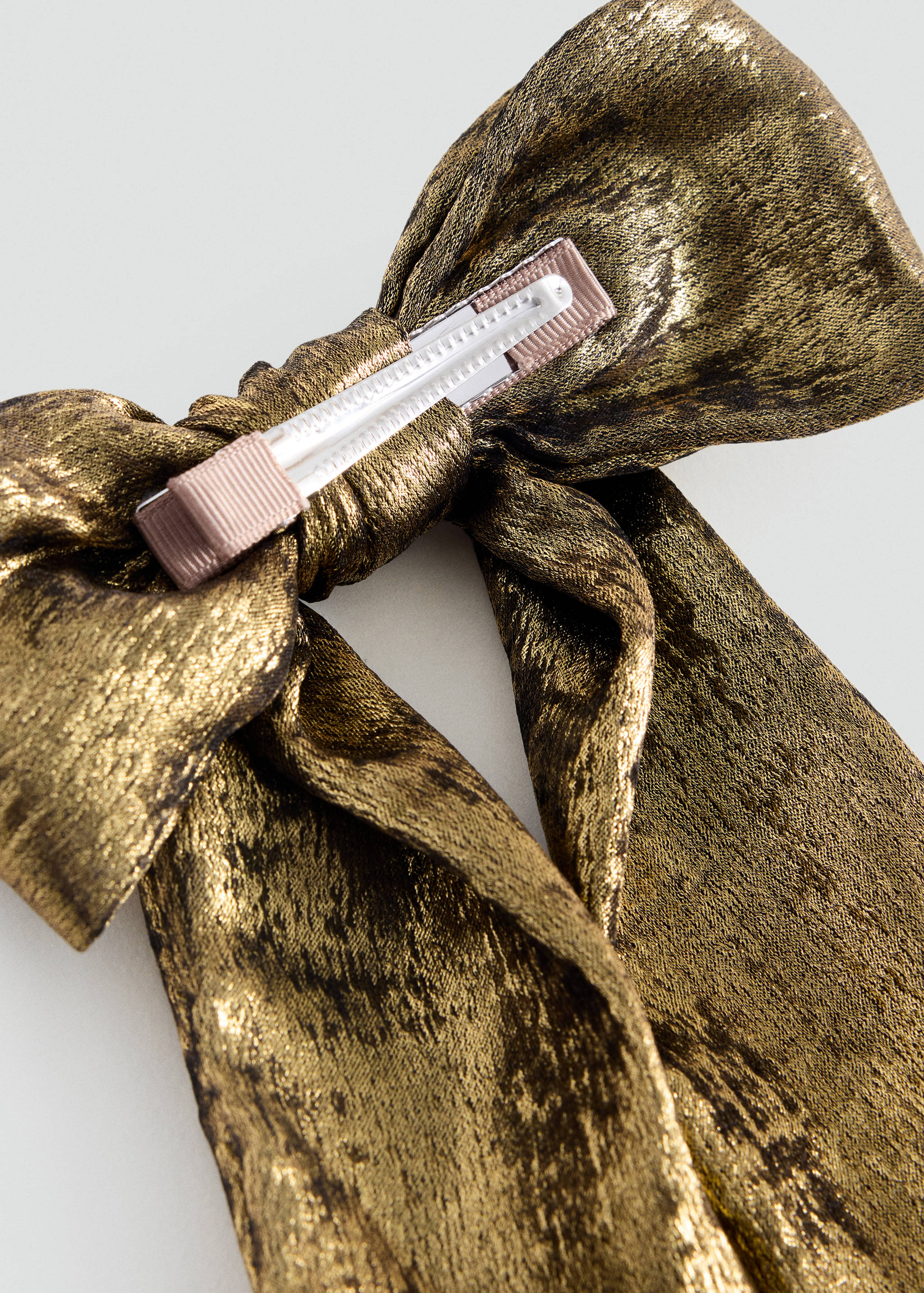 Gold metallic hair clip with a large bow detail.