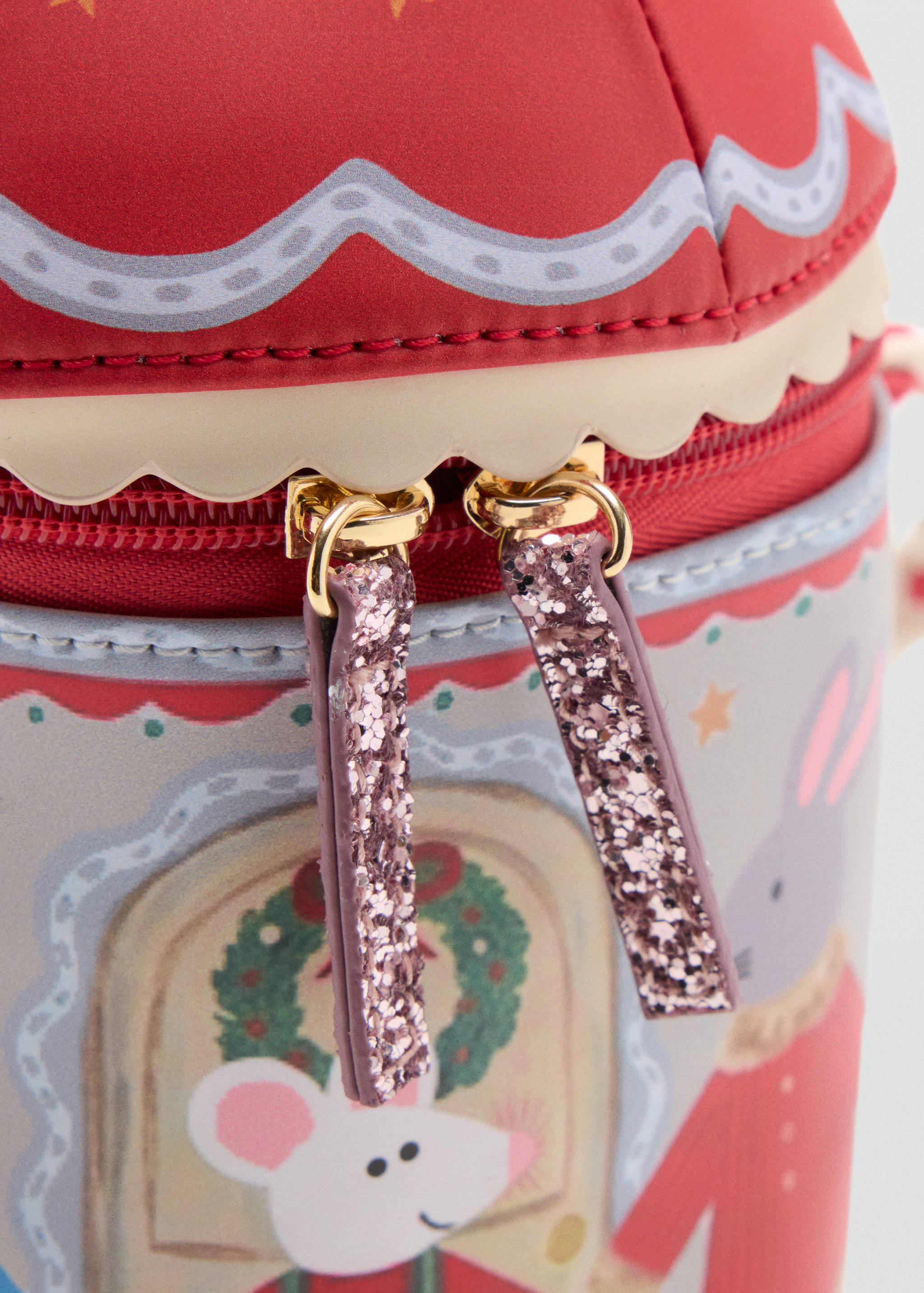 Close-up of glittery pink zipper pulls on a festive kids' bag.