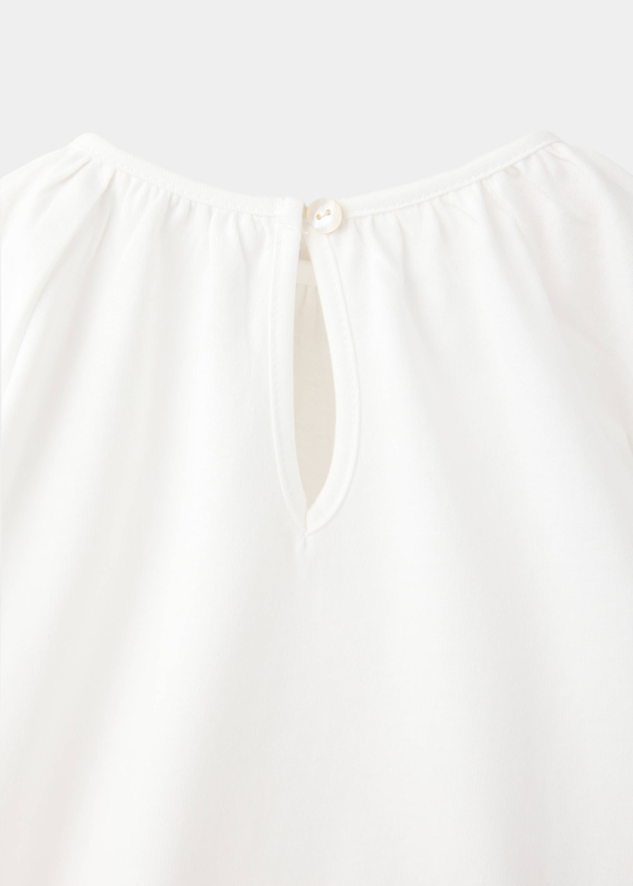 White kids' t-shirt back with buttoned keyhole detail.