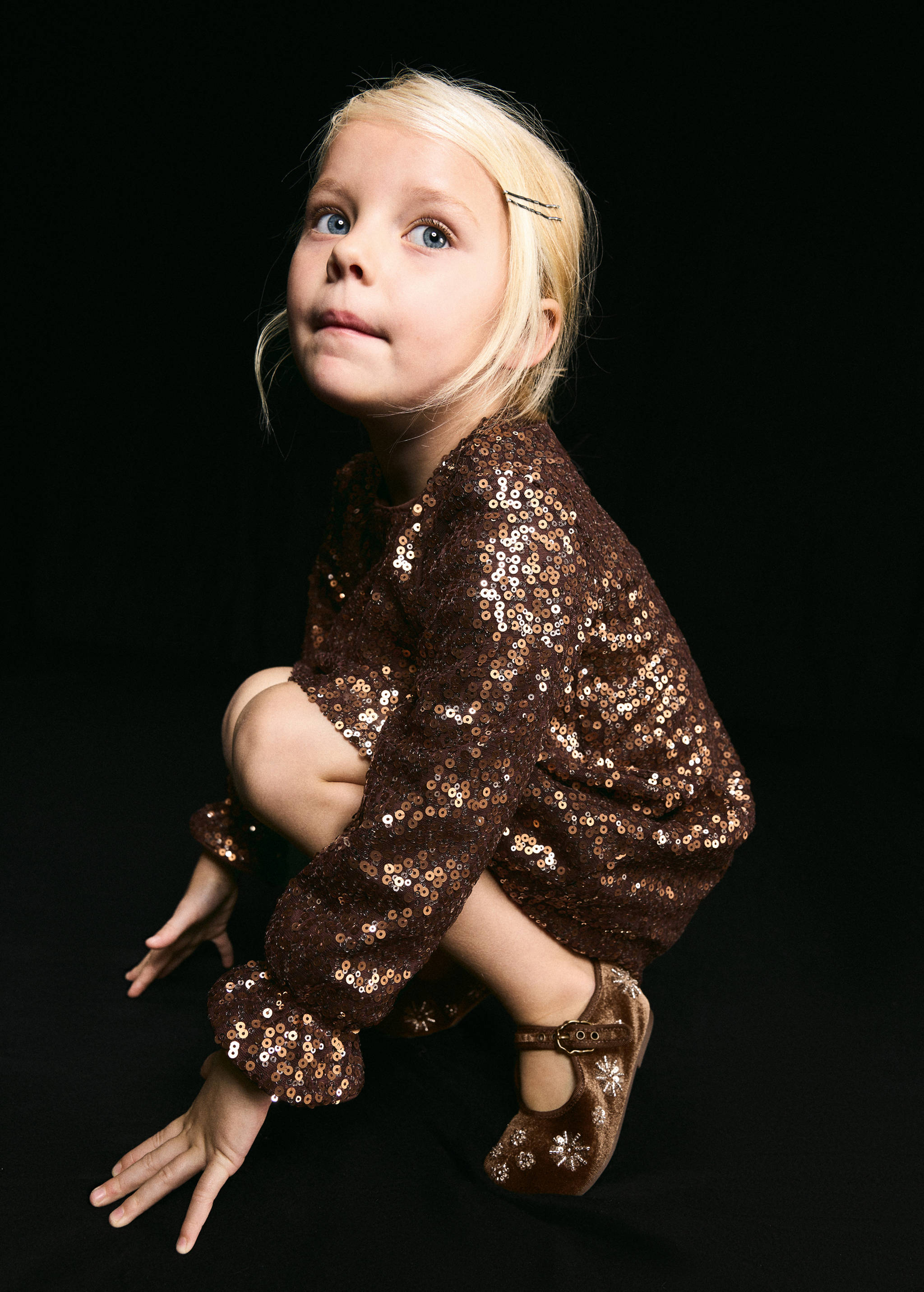 Brown velvet Mary Jane shoes with embroidered details, worn by a child.