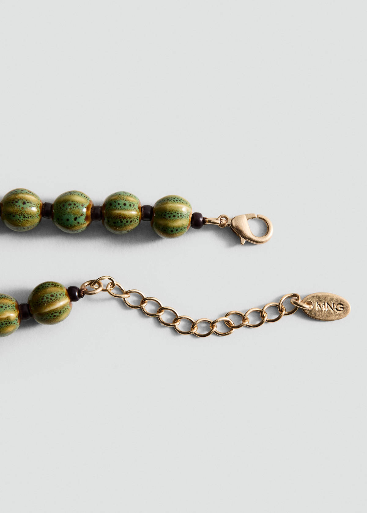 Beaded necklace with ceramic shell appliqué — Gold