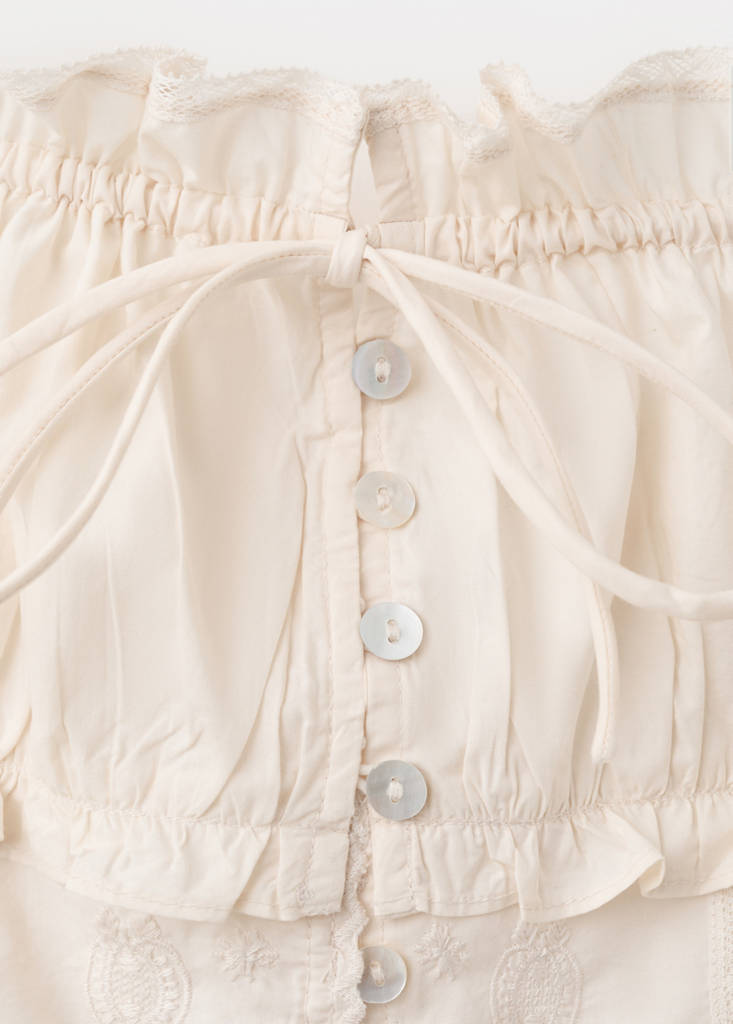 Ruffled top with embroidered details — Ecru