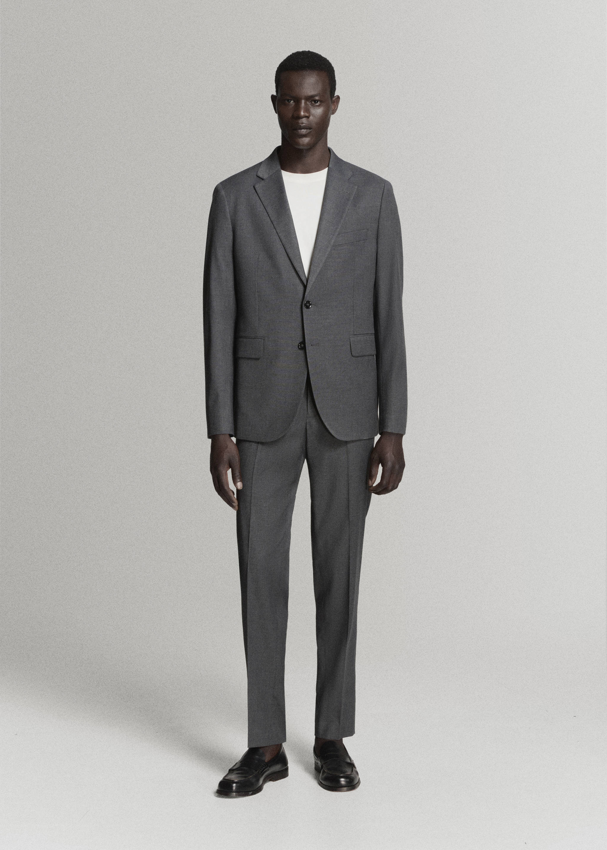 Grey suit trousers with a straight-leg fit and pressed creases, worn with a matching blazer.
