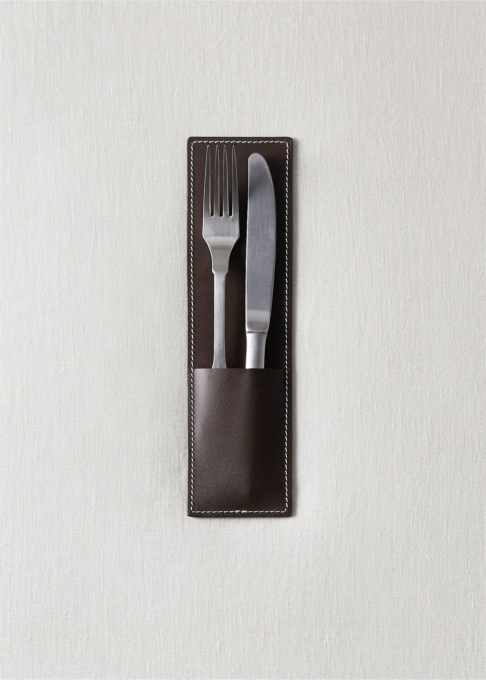 Dark brown leather cutlery holder with white stitching containing a fork and knife on linen., Brown. Ref: 37032560-00.