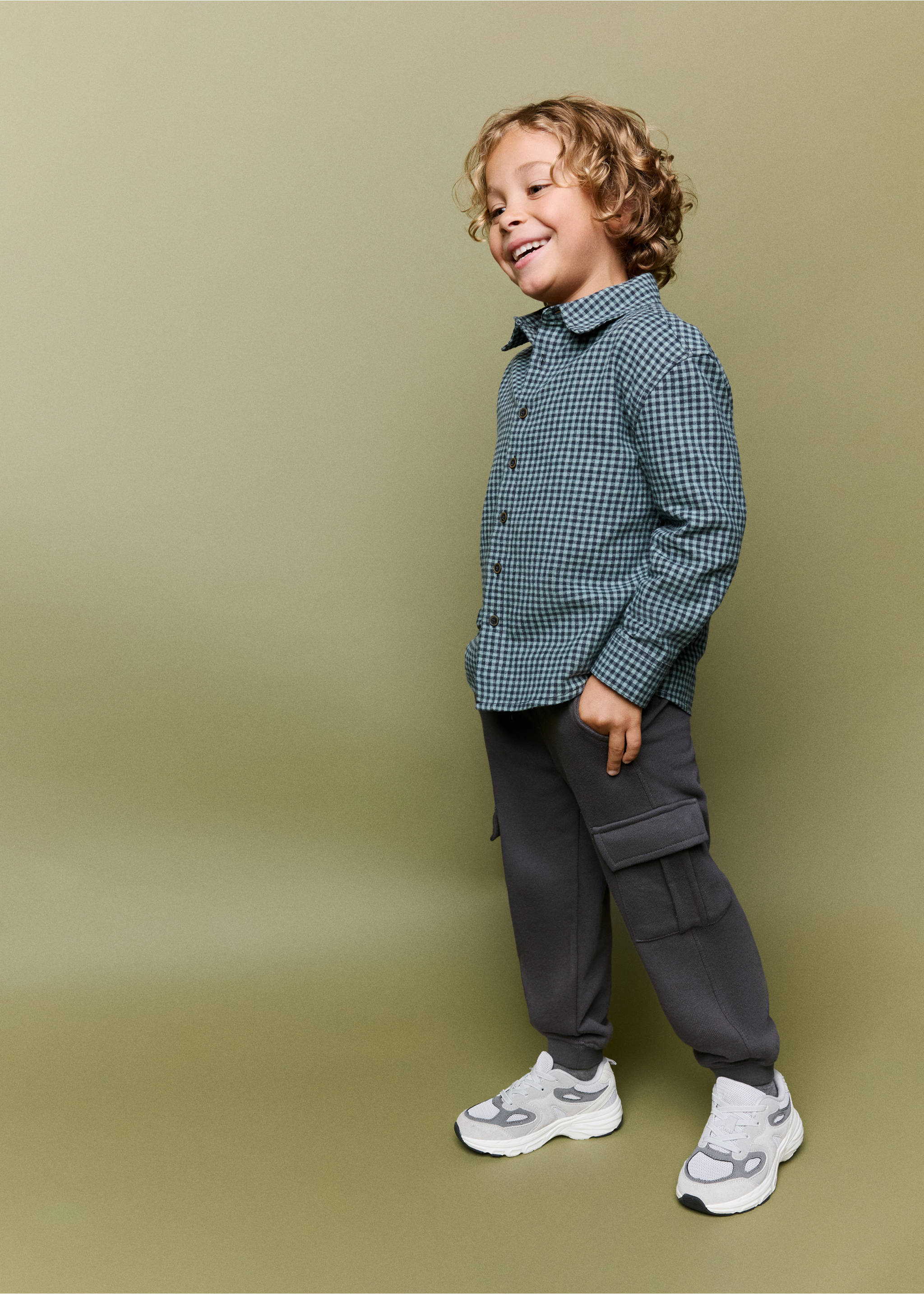 Dark grey cargo trousers with utility pockets, worn with a checkered shirt., Charcoal. Ref: 37033308-00.