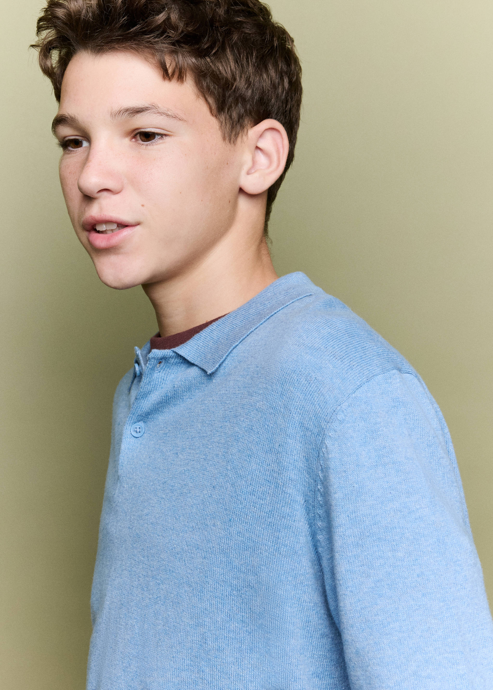 Jersey polo de punto en azul claro con tira de botones, puesto en un modelo joven.