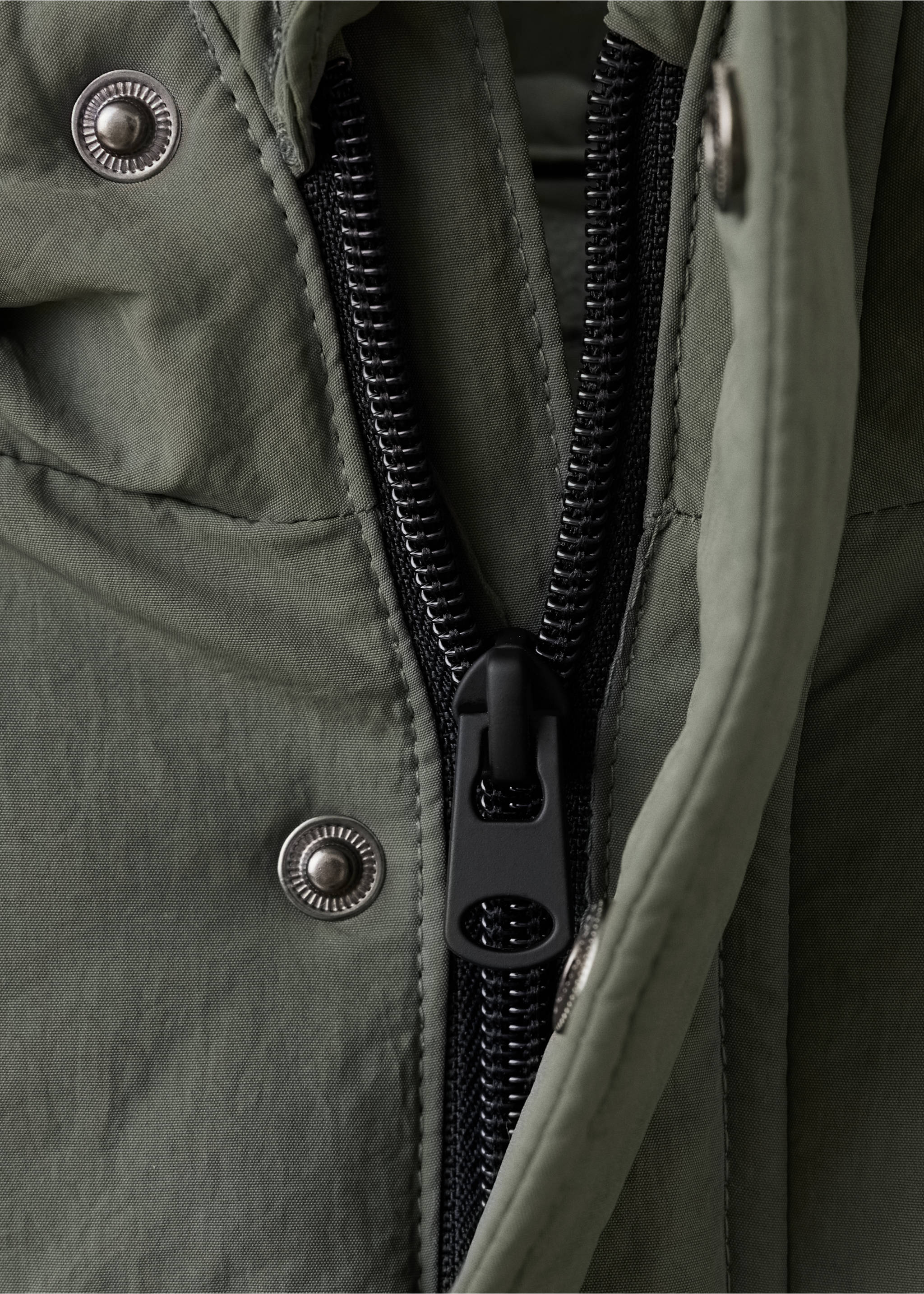 Close-up of an olive green kids' anorak showing its zip and snap button fastening., Green. Ref: 37035151-00.