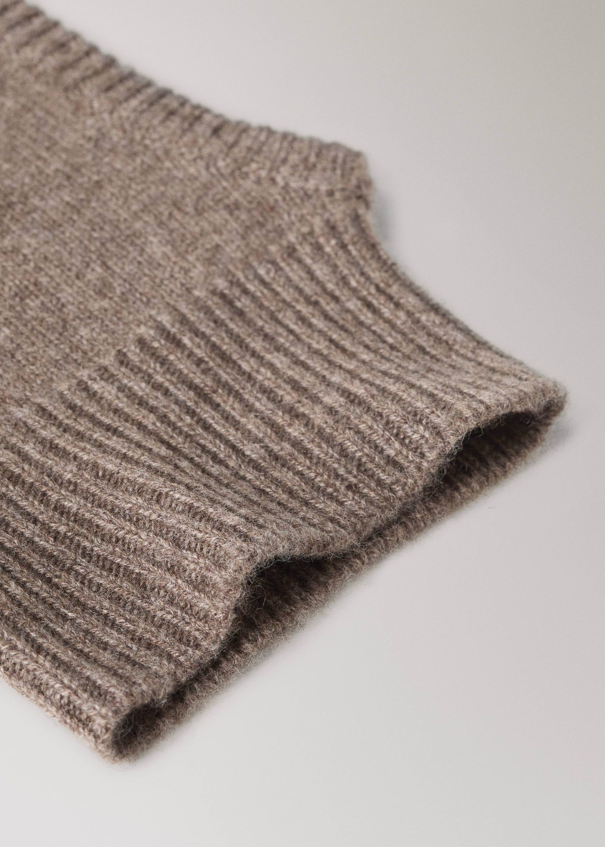 Detalle de gorro de punto marrón que muestra una textura de canalé.