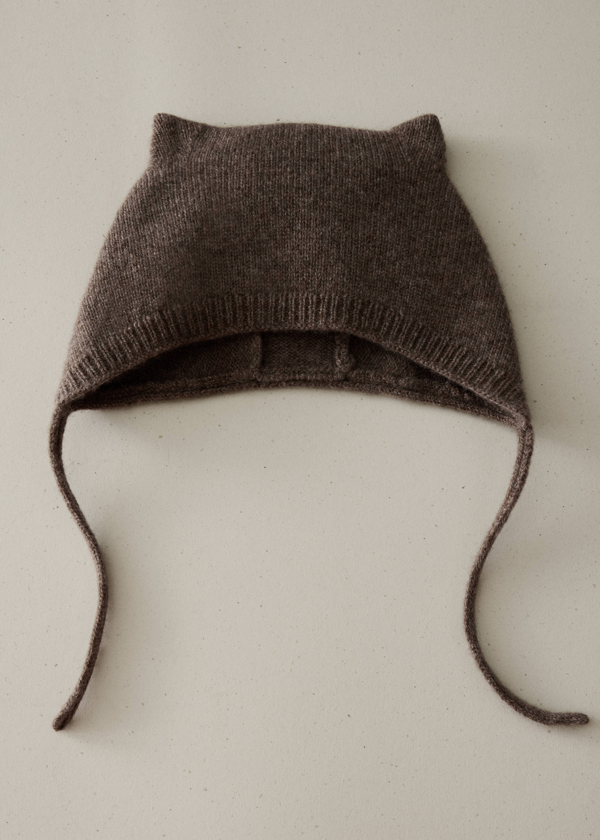 Gorro de punto en marrón oscuro con orejas de gato y cintas para atar.