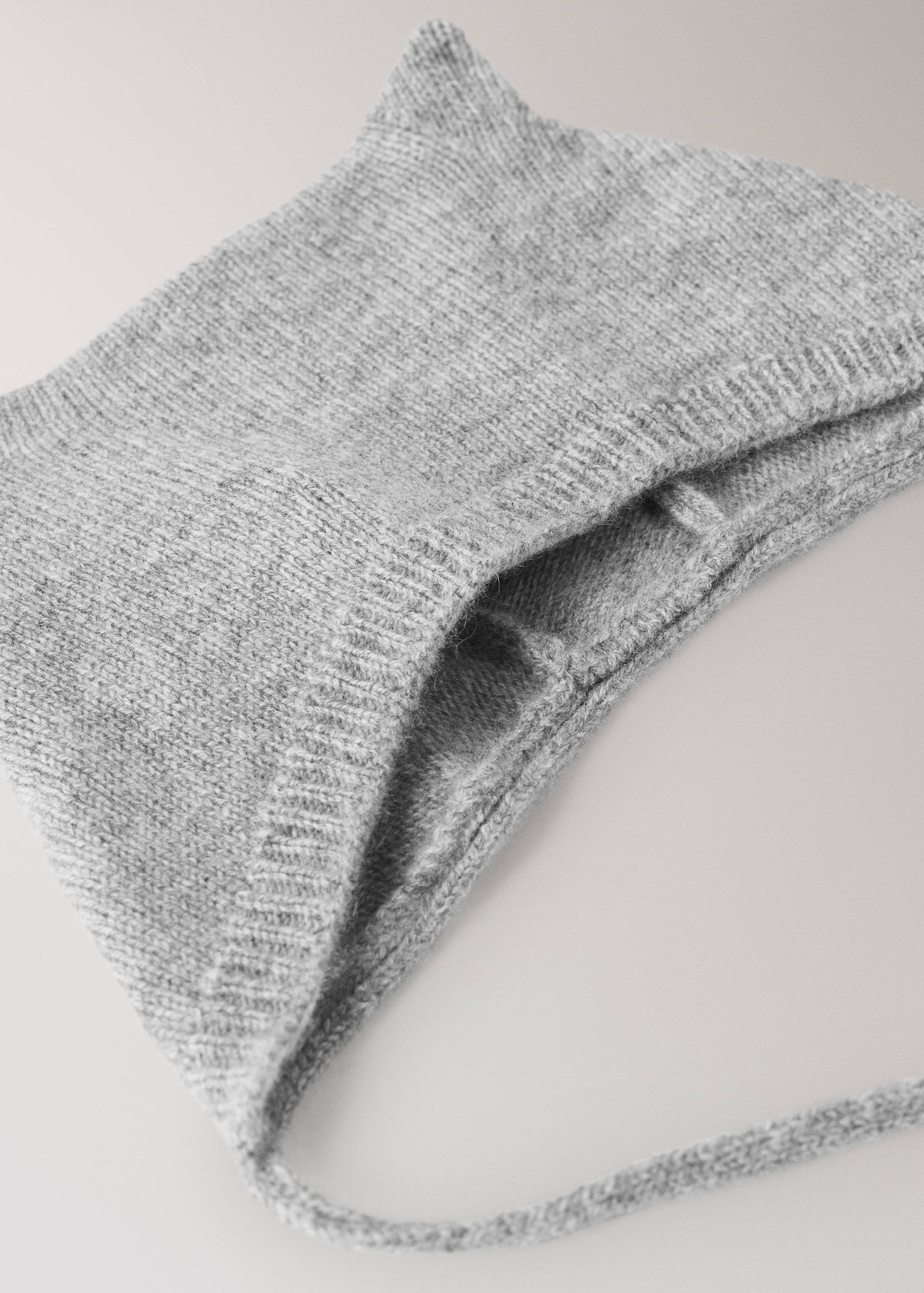 Detalle de gorro de punto gris con vuelta acanalada.