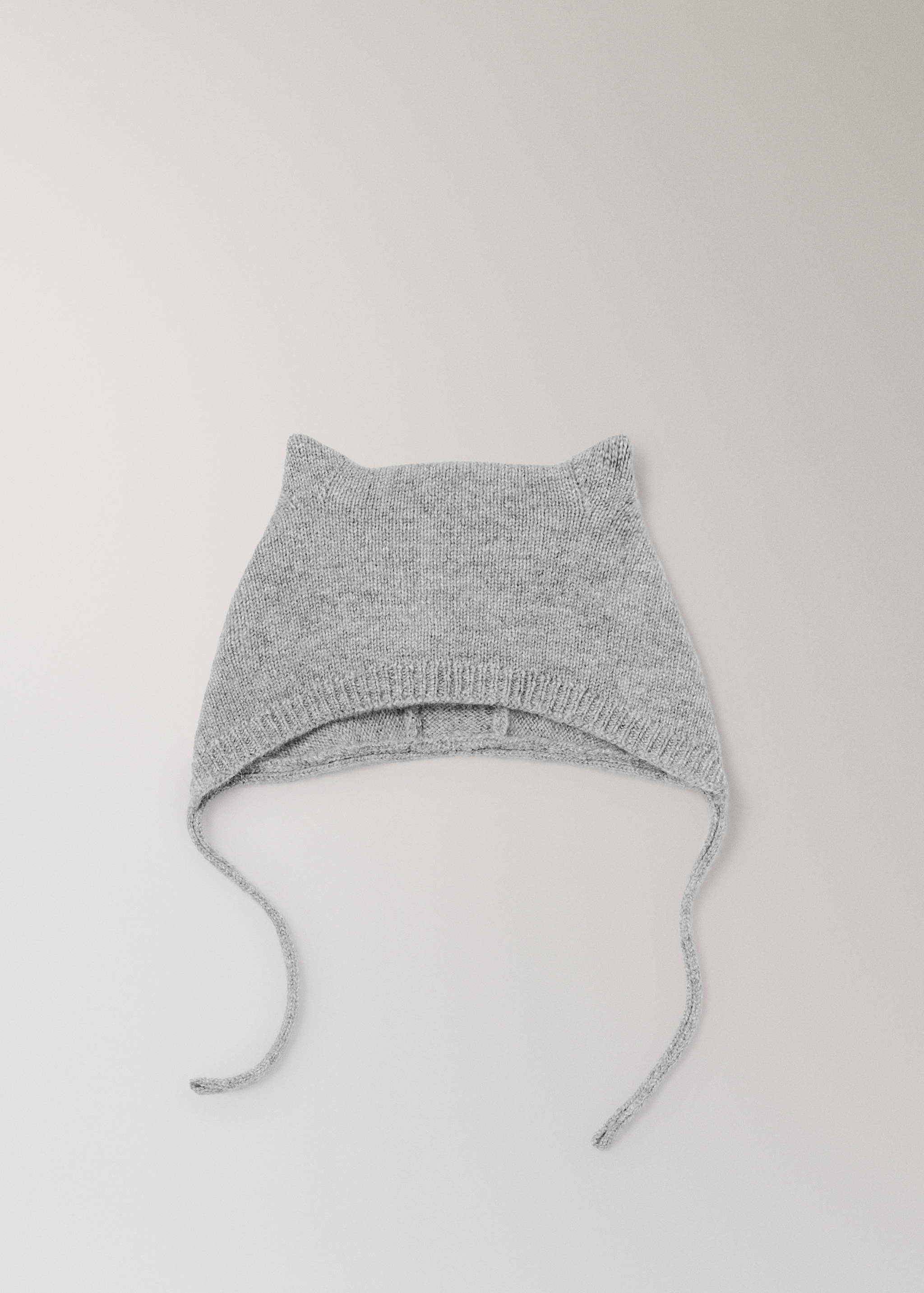 Gorro de punto gris con orejas de gato y cordones para la barbilla.