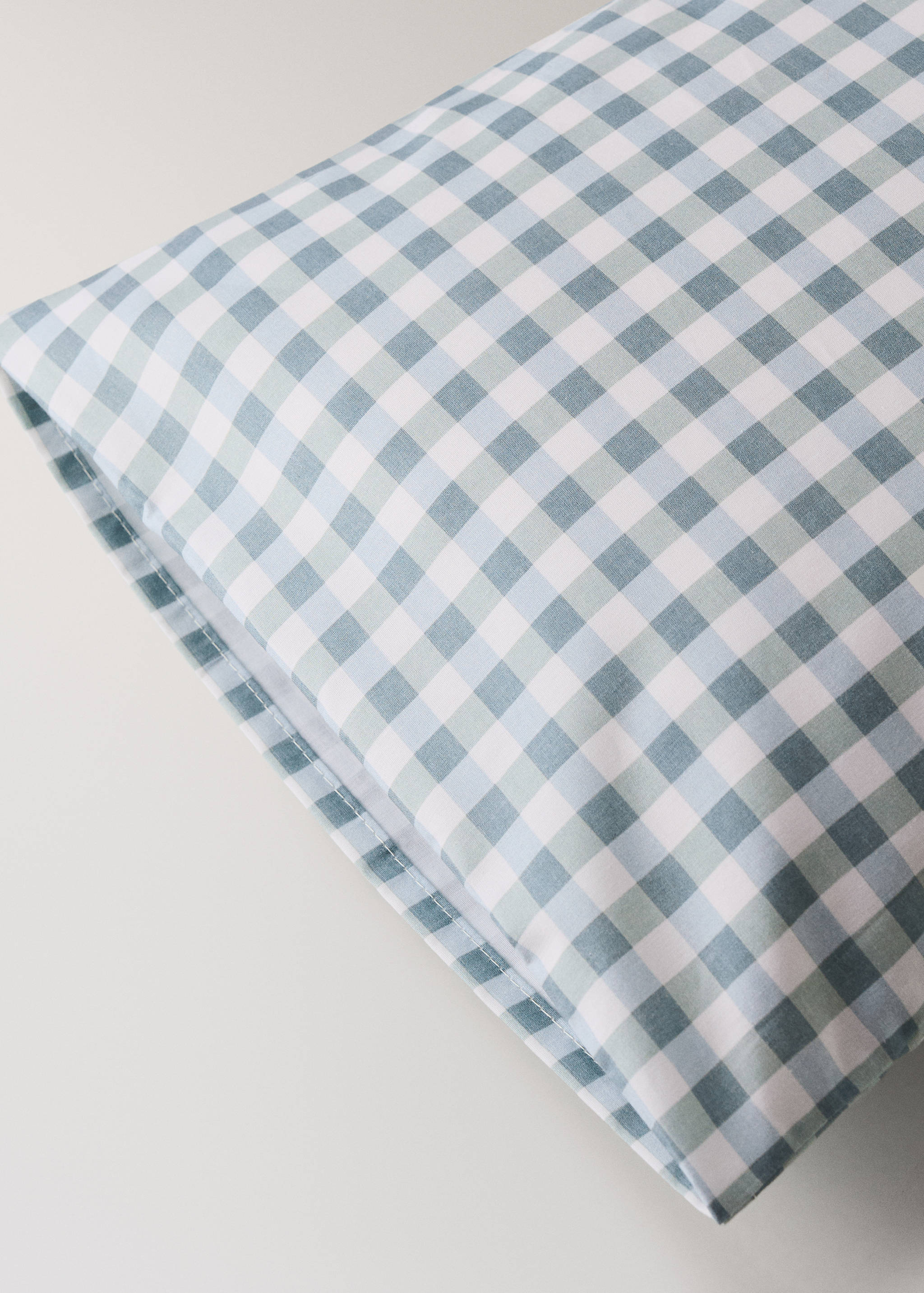 Blue and white gingham check pillowcase, close-up product detail.