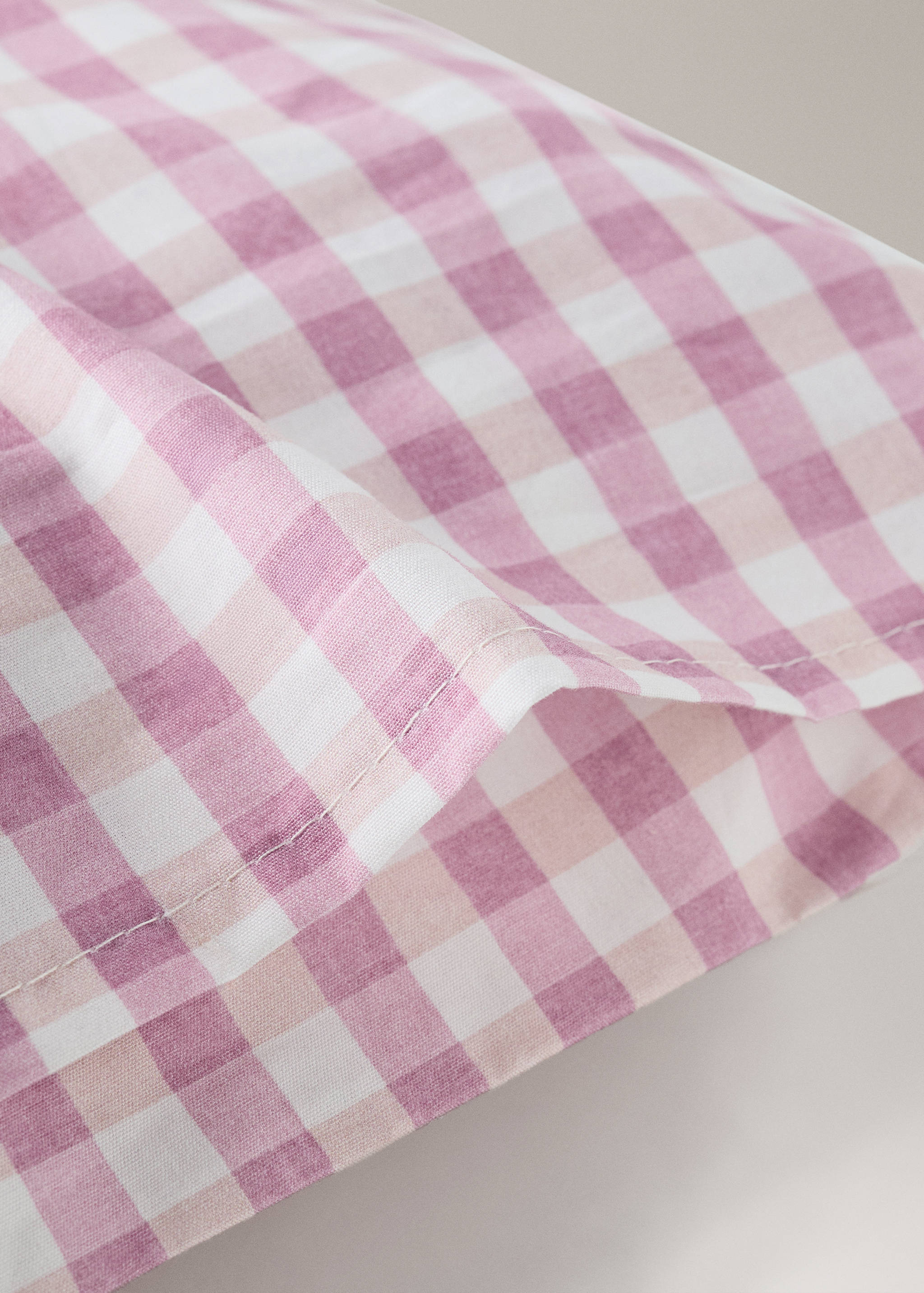 Pink and white gingham check pillowcase detail.